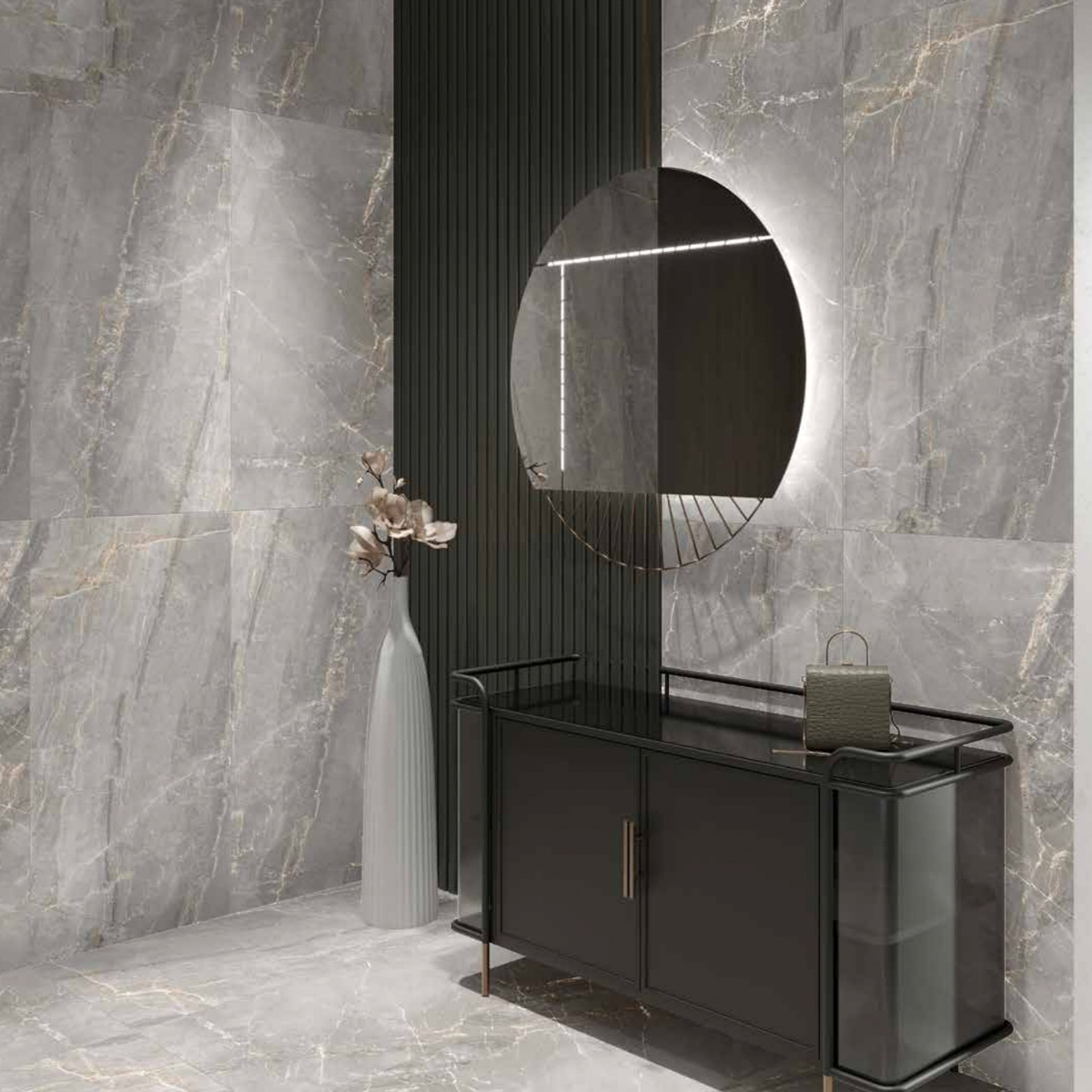 Modern entryway featuring Charme - Grey marble walls and floor, a round backlit mirror above a sleek black console table, and a tall white vase with dried flowers. A small handbag rests on the console.