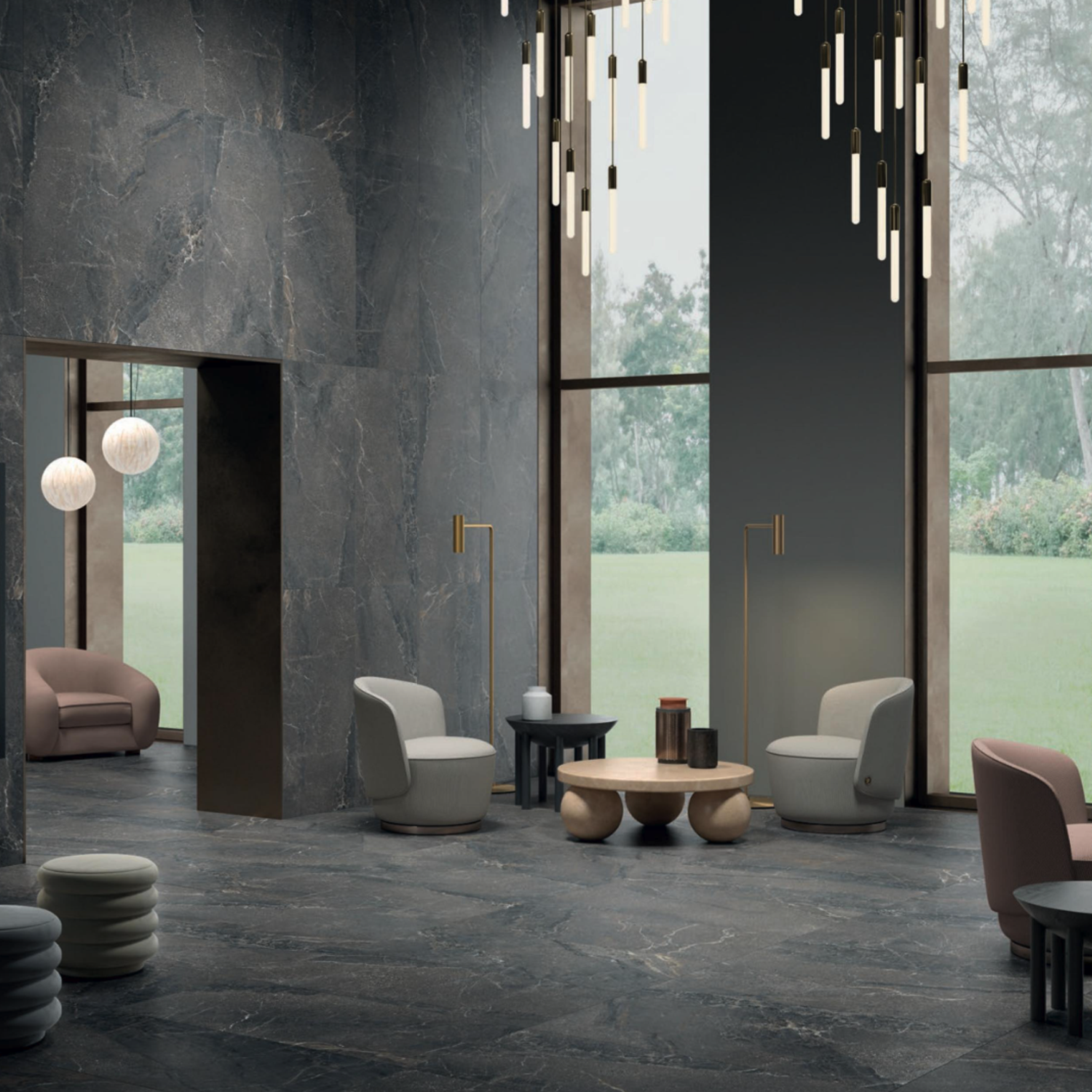 Modern lounge featuring Anthology/Anthea - Dark gray marble floors and walls, stylish armchairs, round tables, tall floor lamps, and pendant lights. Large windows reveal green grass and trees outside.