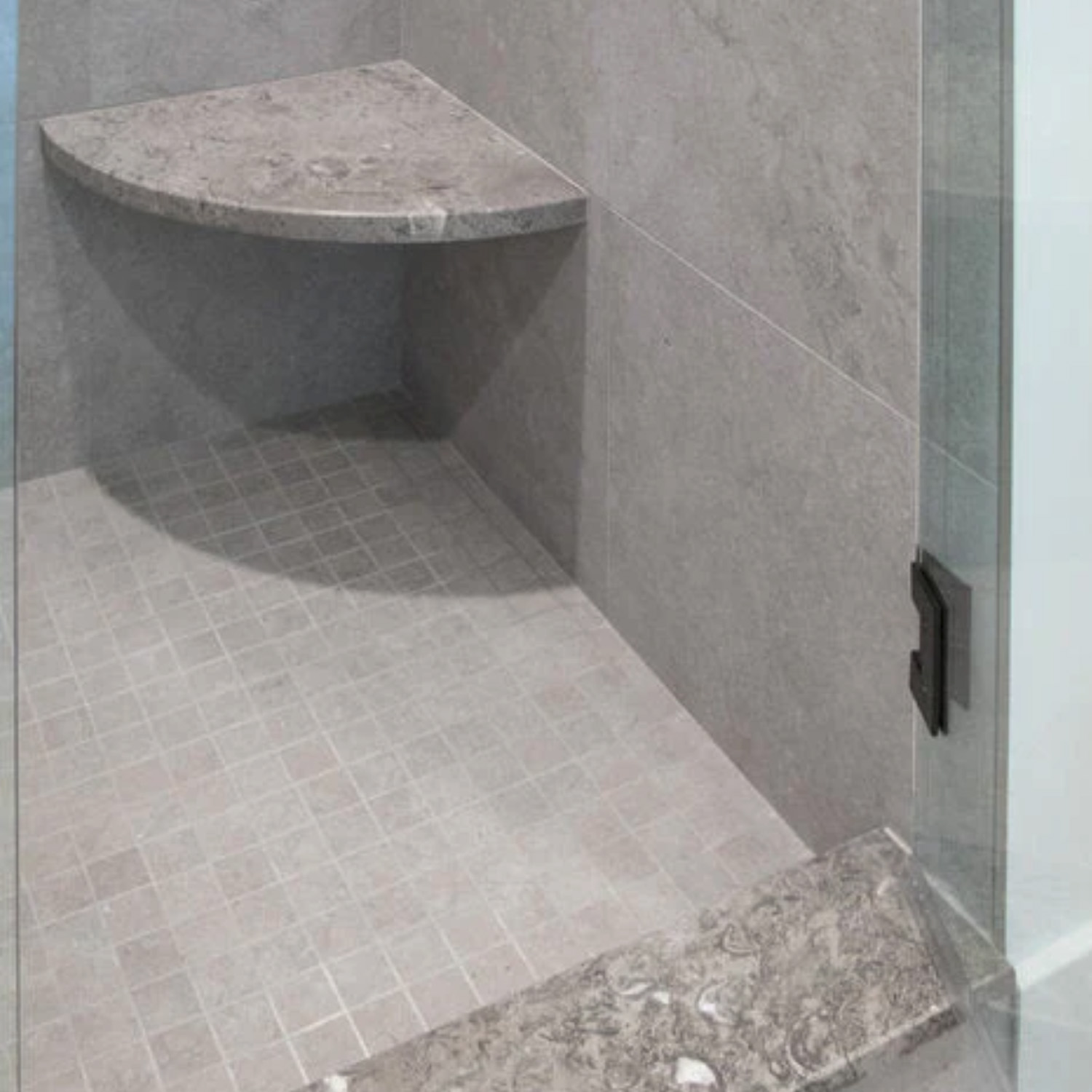 A modern shower with sage gray tiles, featuring a built-in Bath Accessories Corner Shelf in Sage Gray and a glass door with a black handle.