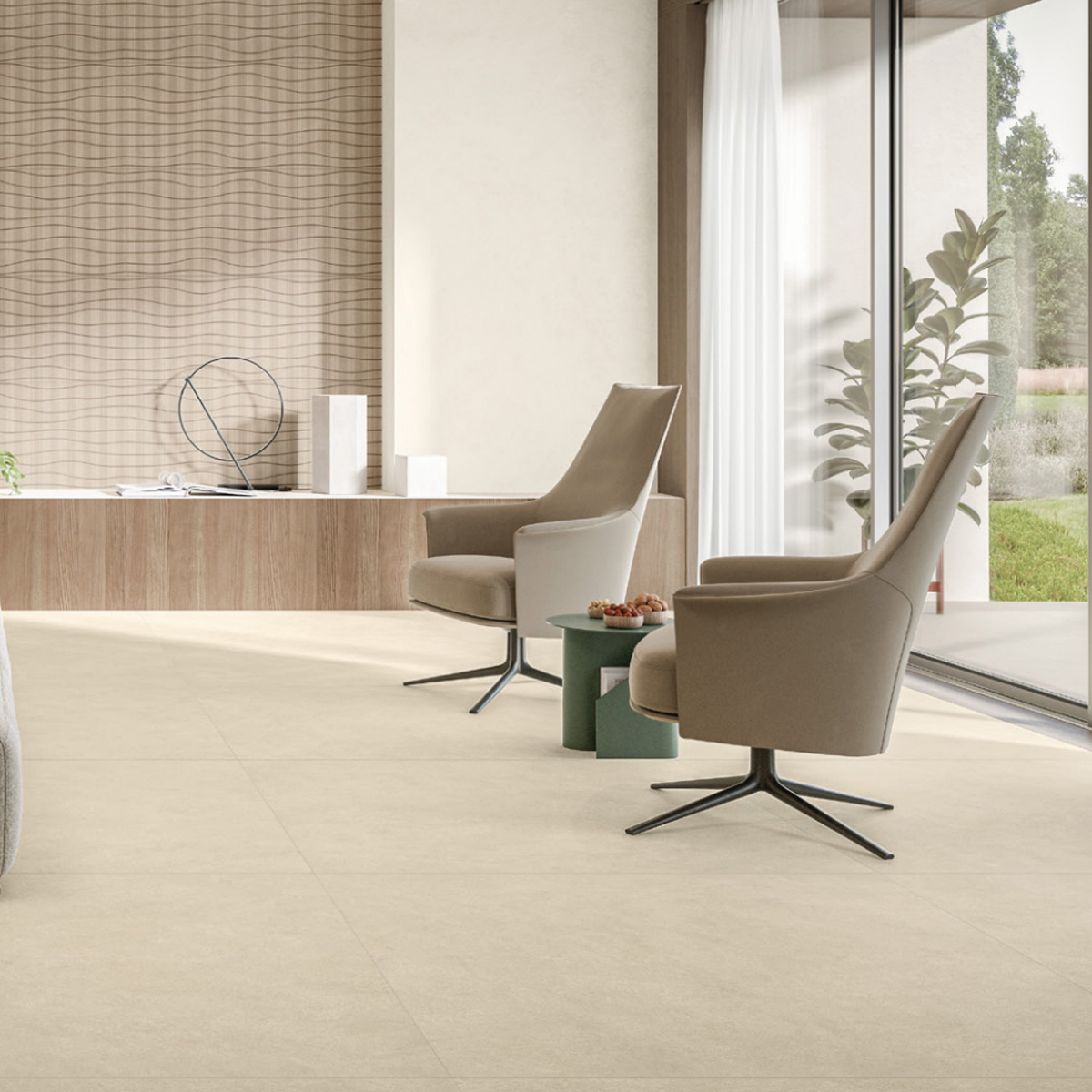 A modern living room features two gray armchairs and a small green table holding fruit and a carton of Boost Natural Pro - Oat. The space is brightened by large windows with white curtains, a decorative wall with wavy patterns, a plant, and minimalist decor.
