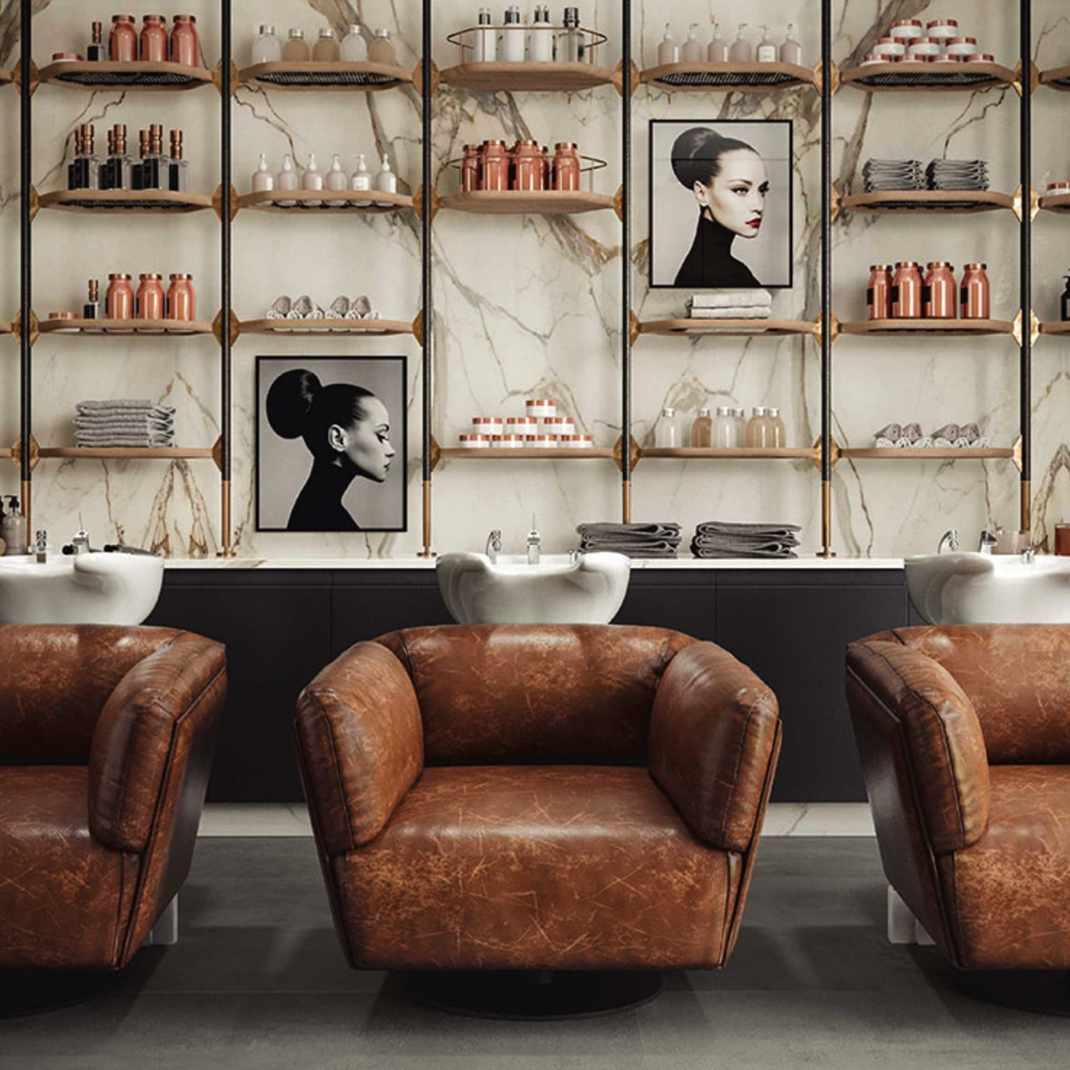 Three brown leather salon chairs face marble sinks. Behind them, shelves display bottles, towels, and framed fashion portraits. The backdrop is a Calacatta Imperiale marble wall with gold accents, creating a stylish, modern salon interior.
