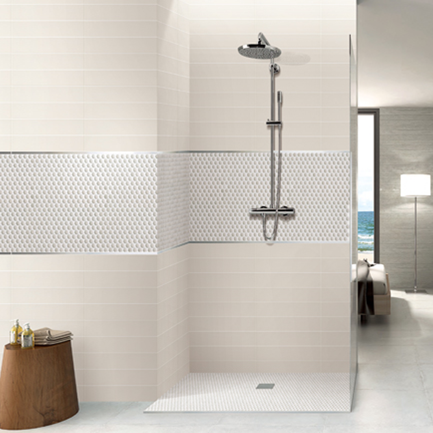 Modern walk-in shower featuring a wall-mounted rain shower head, handheld shower, and Chameleon - Opal tiles in white and patterned designs. A wooden stool sits beside the shower area, with the living space and a lamp visible in the background.