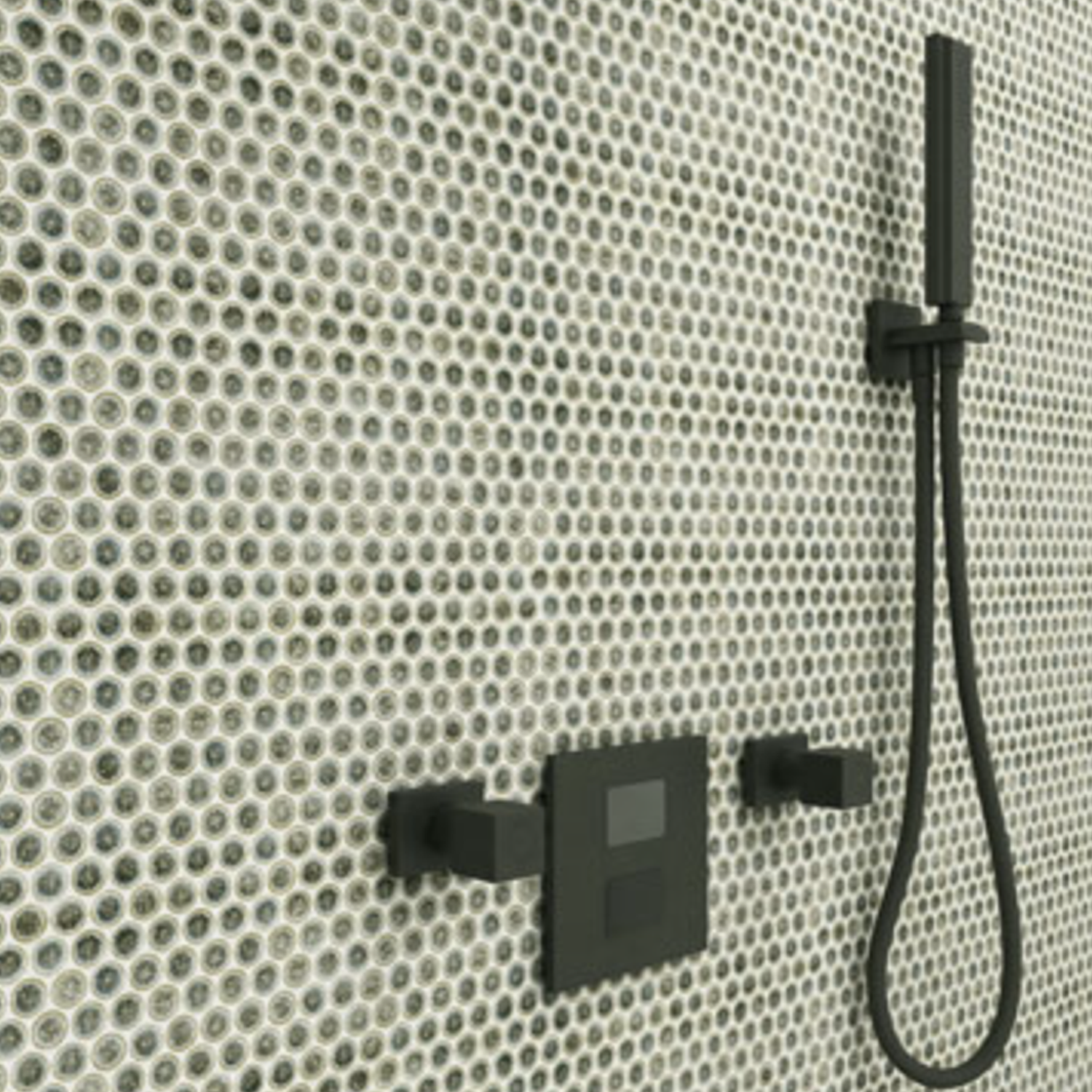 A modern shower with black fixtures is mounted on a wall covered in Chameleon - Sage Green circular glass mosaic tiles arranged in a grid pattern.