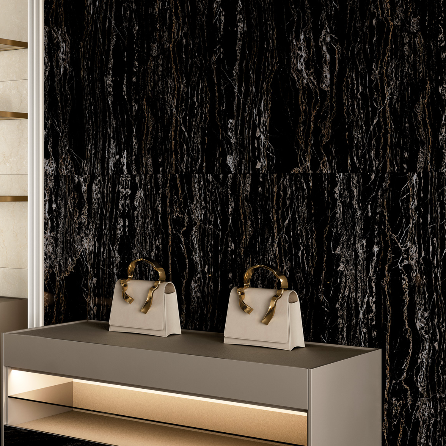 Two Classic Boutique - Regalia Nero beige handbags with gold handles sit on a modern gray display table in front of a black marble-textured wall, with a softly lit shelf beneath the tabletop.