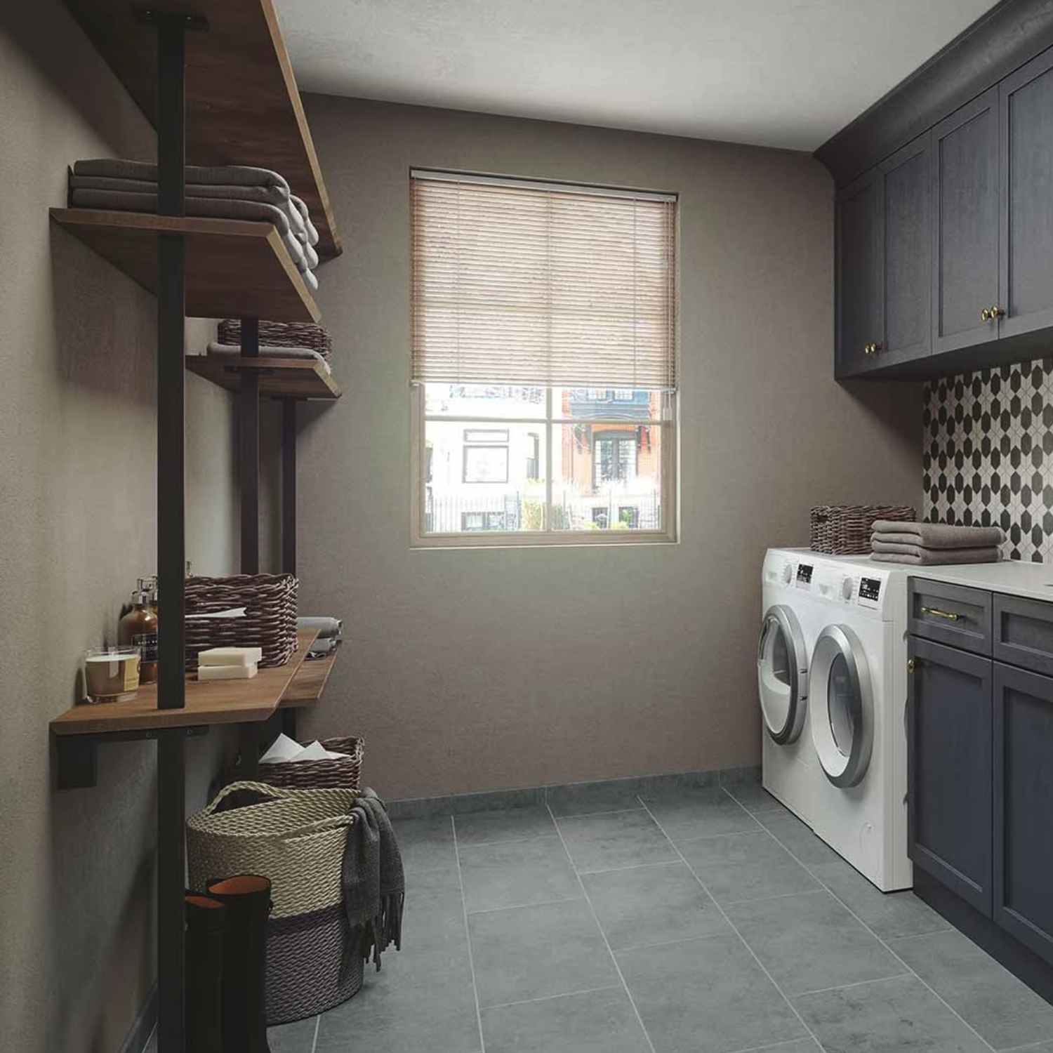 Modern laundry room with a washer and dryer, shelves holding baskets and folded towels, cabinets above, and a window with blinds letting in natural light. Cove - Ocean patterned backsplash tiles add decoration.
