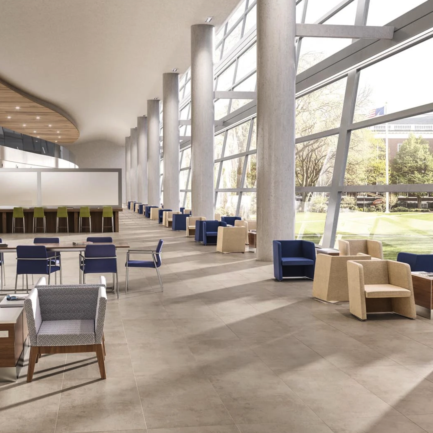 Modern, airy lounge with large windows, Cove - Pebble floor tiles, blue and tan chairs, small tables, and an abundance of natural light. Trees and a building are visible outside through the expansive glass wall.
