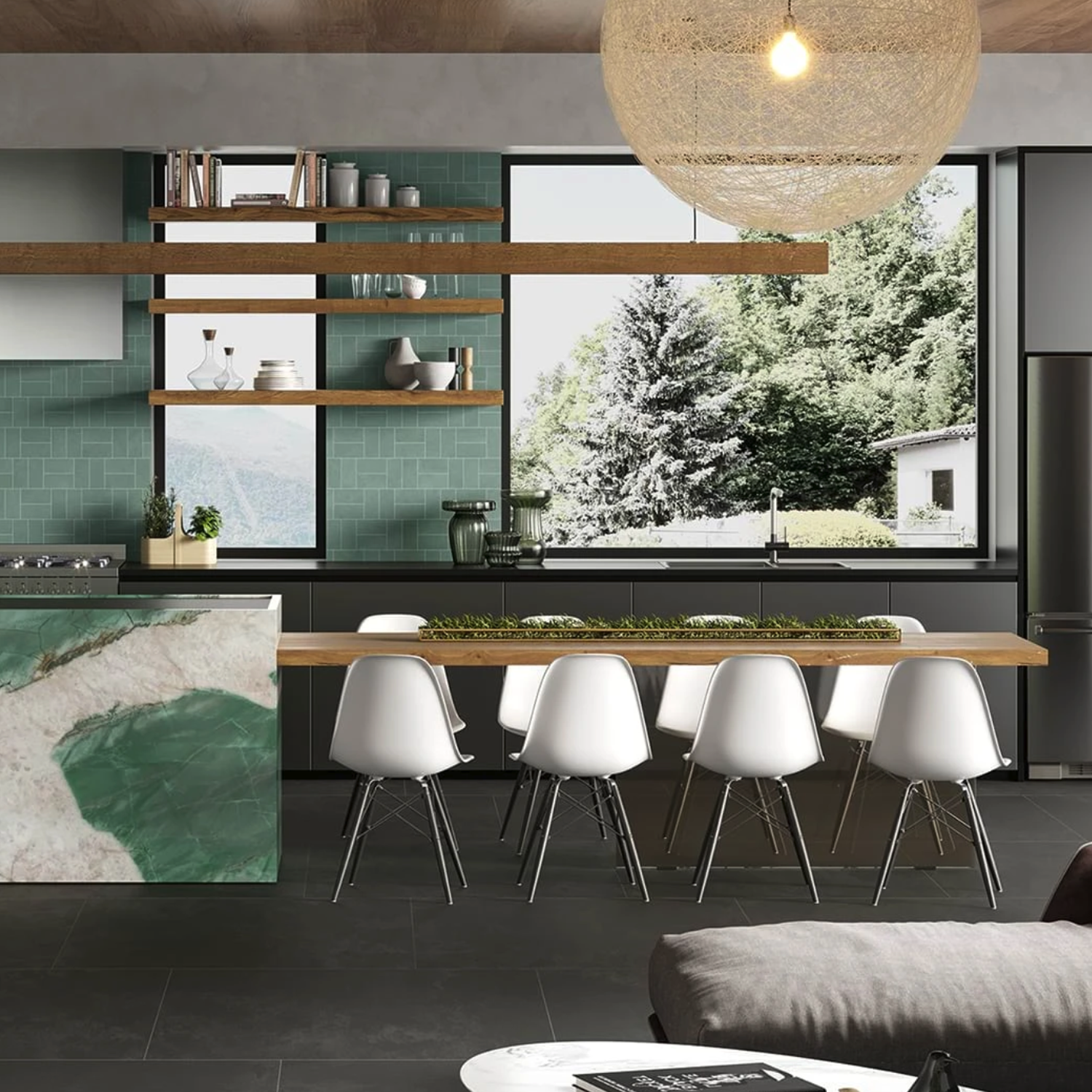 Modern kitchen featuring a green accent wall, marble island, open wood shelves, large windows revealing trees outside, a wooden table surrounded by white chairs, and a hanging woven light fixture—all complemented by the sleek Cove Terra - Black.