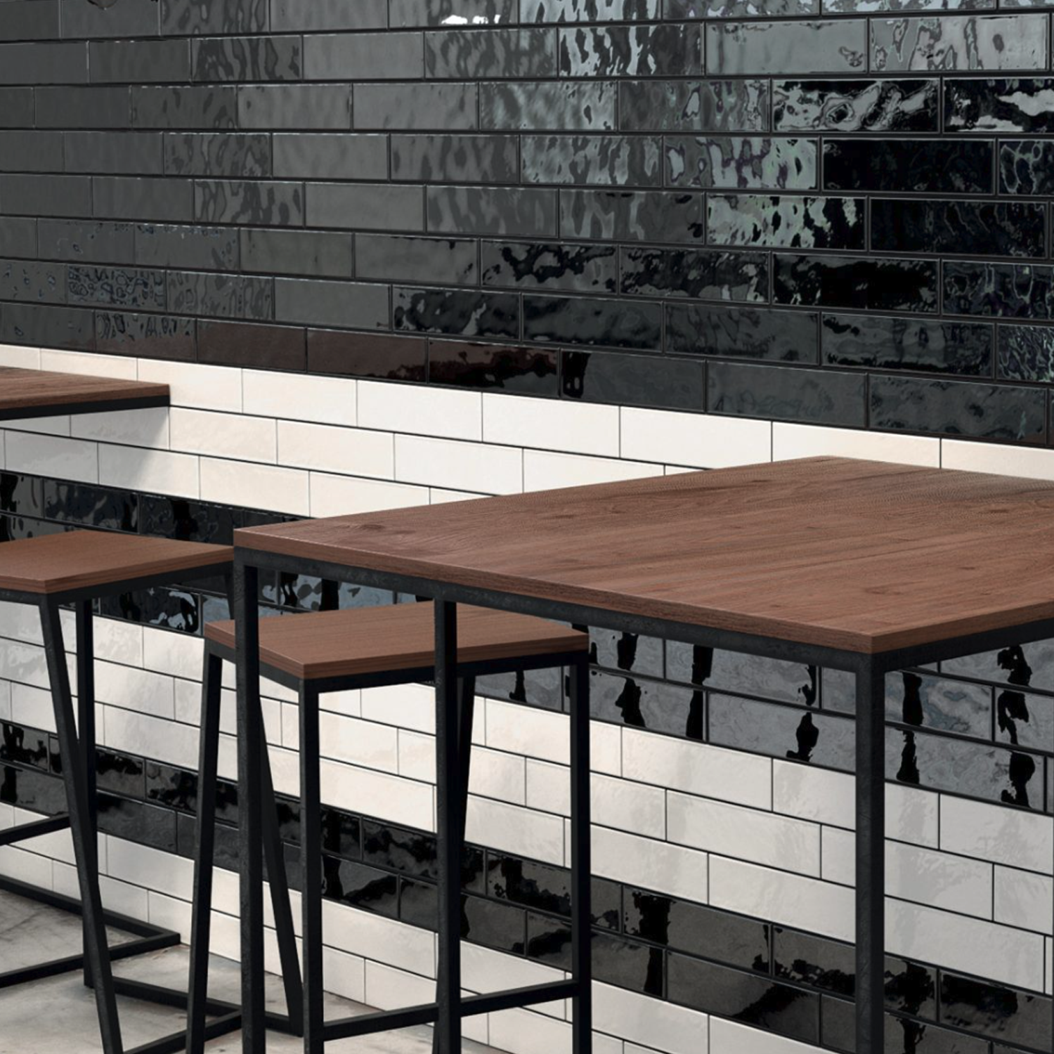 Modern café setting with wooden tables and metal stools. The wall features Cromia26 - Bianco glossy white subway tiles arranged in horizontal stripes with black accents, creating a sleek, contemporary look.
