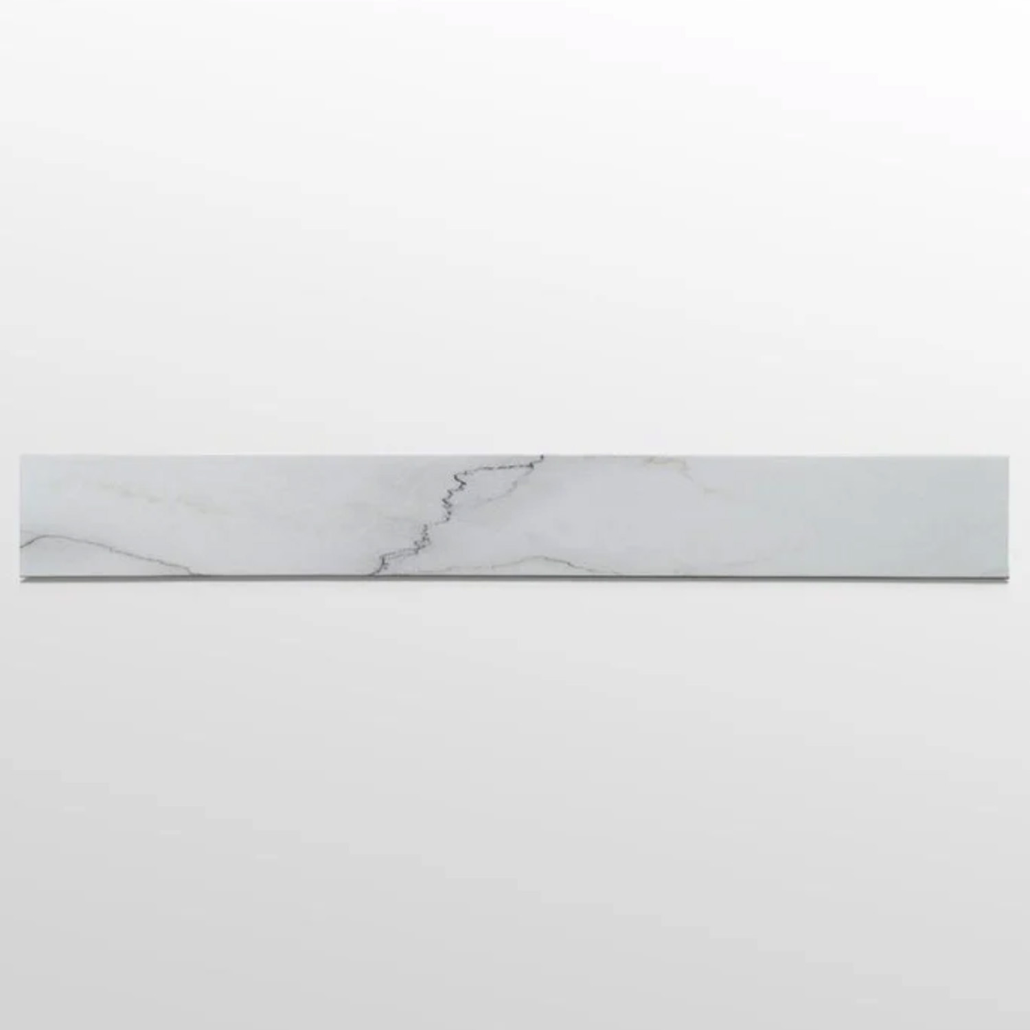 A long, narrow rectangular tile from the Curbs - Colorado Calacatta collection, featuring subtle gray veining on a white surface, placed against a plain light gray background.