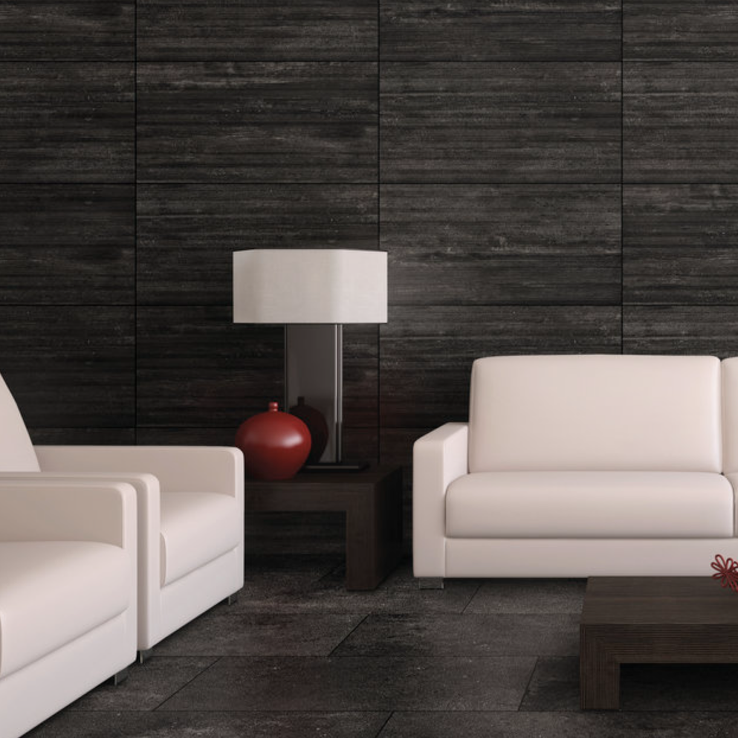 Modern living room with two white sofas, a dark wood side table holding a lamp and red vase, a matching coffee table, and Ecocrete - Weathered Black wall panels in the background.