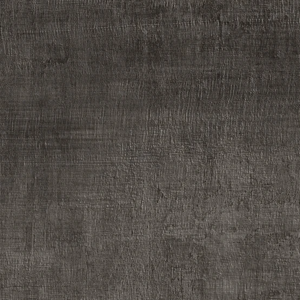 A Fray - Metal Black chair sits on a large, dark tile floor next to a wall with white brick. A skateboard with colorful graphics leans against the wall. A small section of a patterned rug is visible in the corner.