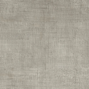 A wooden stool with bath products sits on a floor tiled in Fray - Metal Gray next to a beige tiled wall.