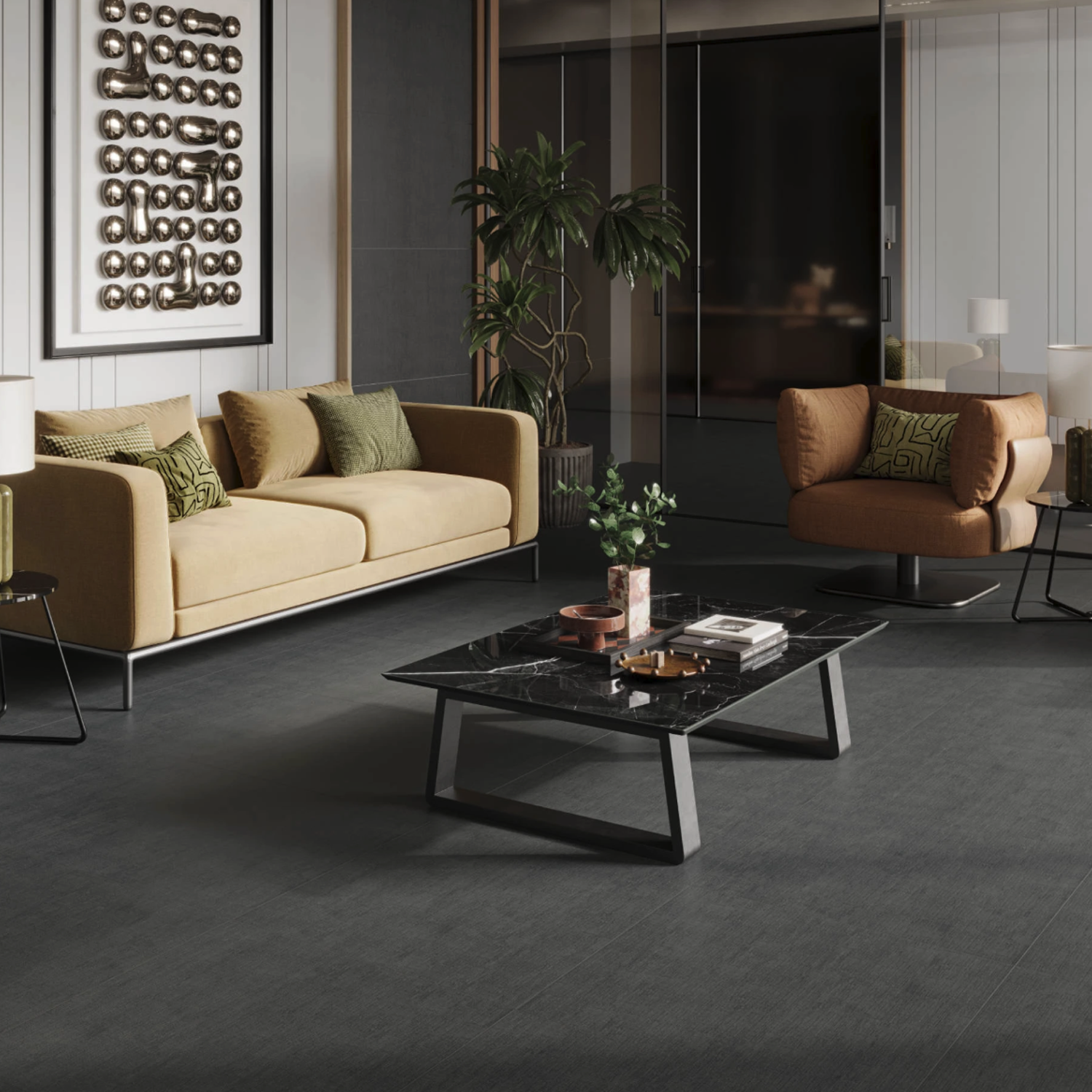 Modern living room featuring the Fray X - Graphite sofa, paired with an armchair, a black marble coffee table, green plants, abstract wall art, and dark flooring. Neutral tones and soft lighting create a cozy, stylish atmosphere.