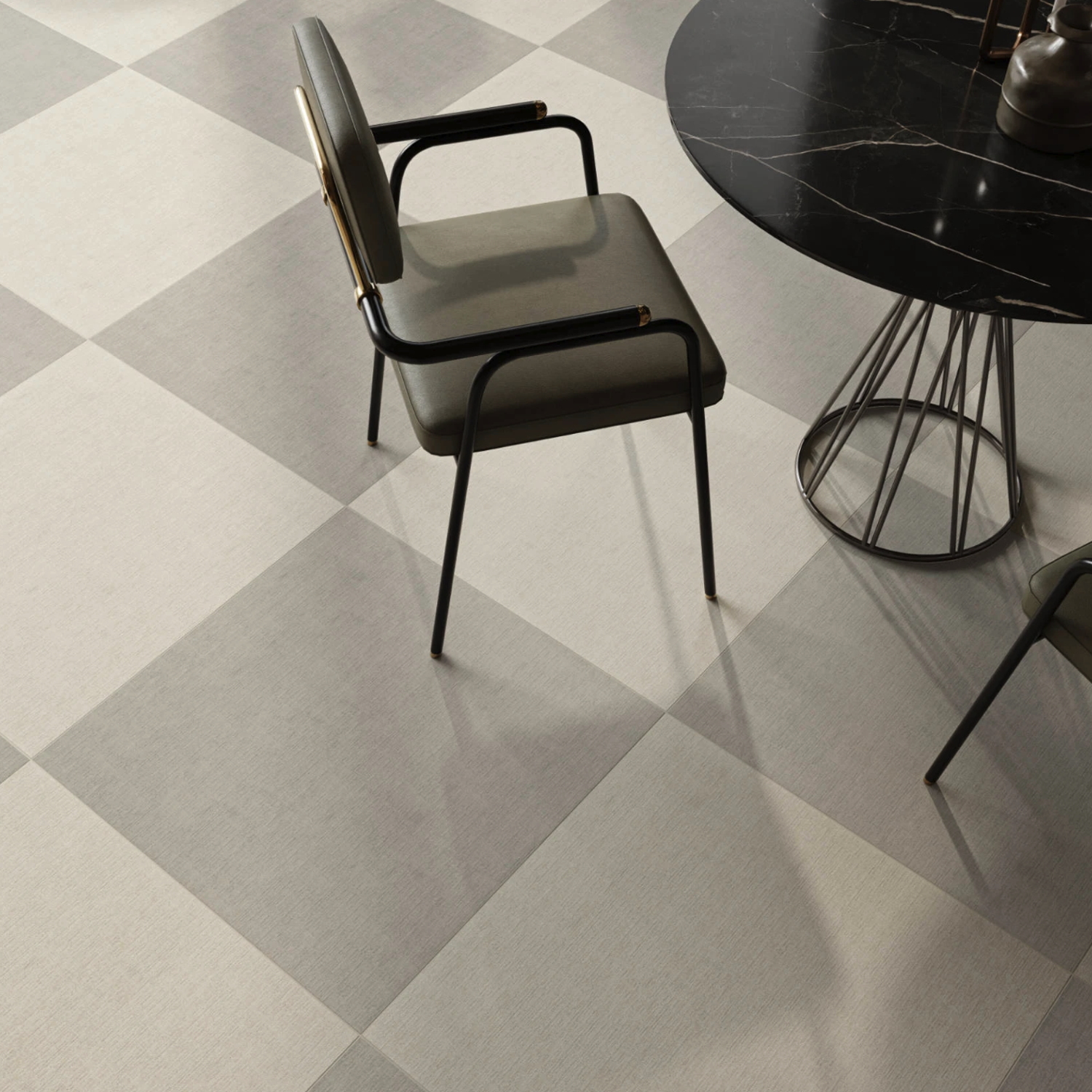 The Fray X - Moon chair with black arms is paired with a round black marble table, both set on a floor featuring large light and dark gray checkered tiles.
