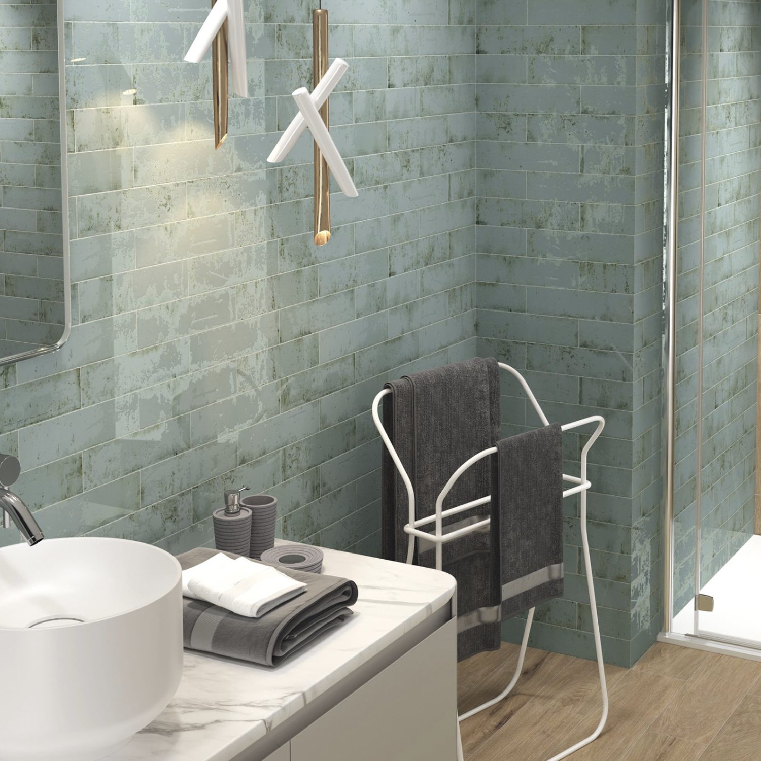 Modern bathroom featuring Grunge - Aqua green textured tiles, a white vessel sink set on a marble countertop, dark gray towels displayed on a white rack, and a shower with a glass door. Contemporary pendant lights hang above the sink.