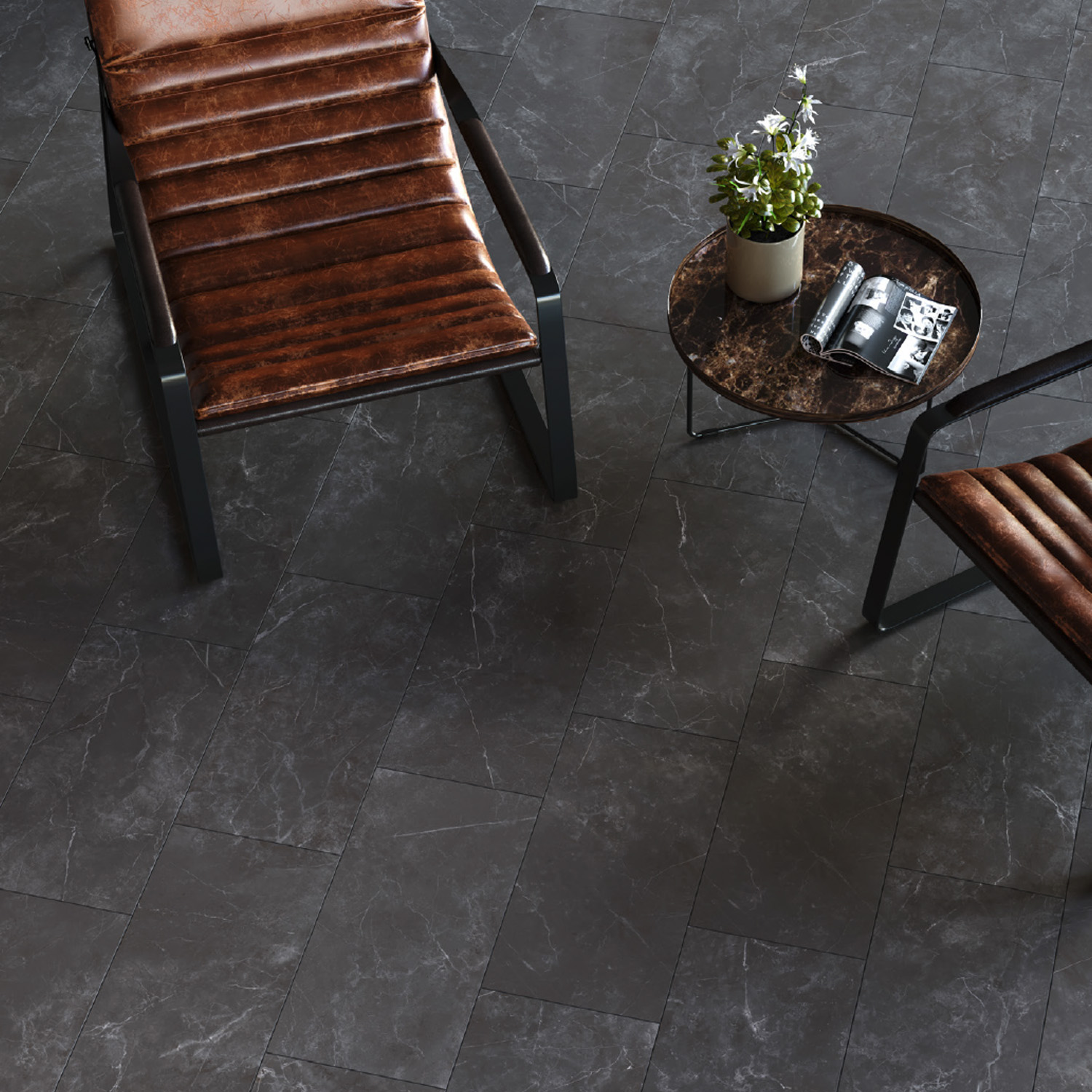 Two brown leather chairs sit on a Keystone 2.0 - Nero floor next to a small round table with a plant and magazines on top.