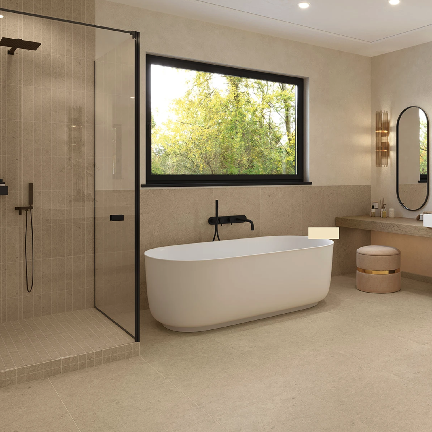 Modern bathroom featuring Legacy Limestone - Ivory tile flooring and walls, a freestanding white bathtub, walk-in glass shower, large window, vanity with oval mirror, and abundant natural light.