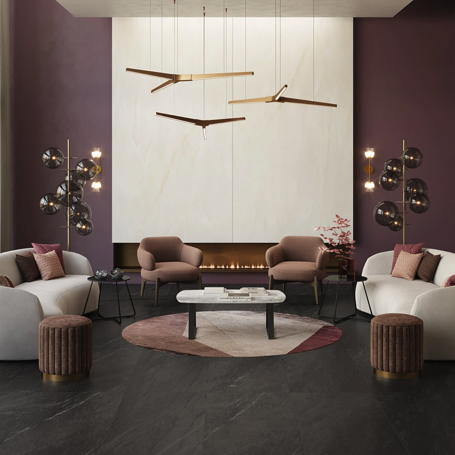 Modern living room featuring mauve walls, a white fireplace, contemporary gold lights, plush chairs, white sofas, velvet ottomans, a geometric rug, and Legacy Marblestone - Black flooring. Minimalist decor creates a warm and elegant atmosphere.