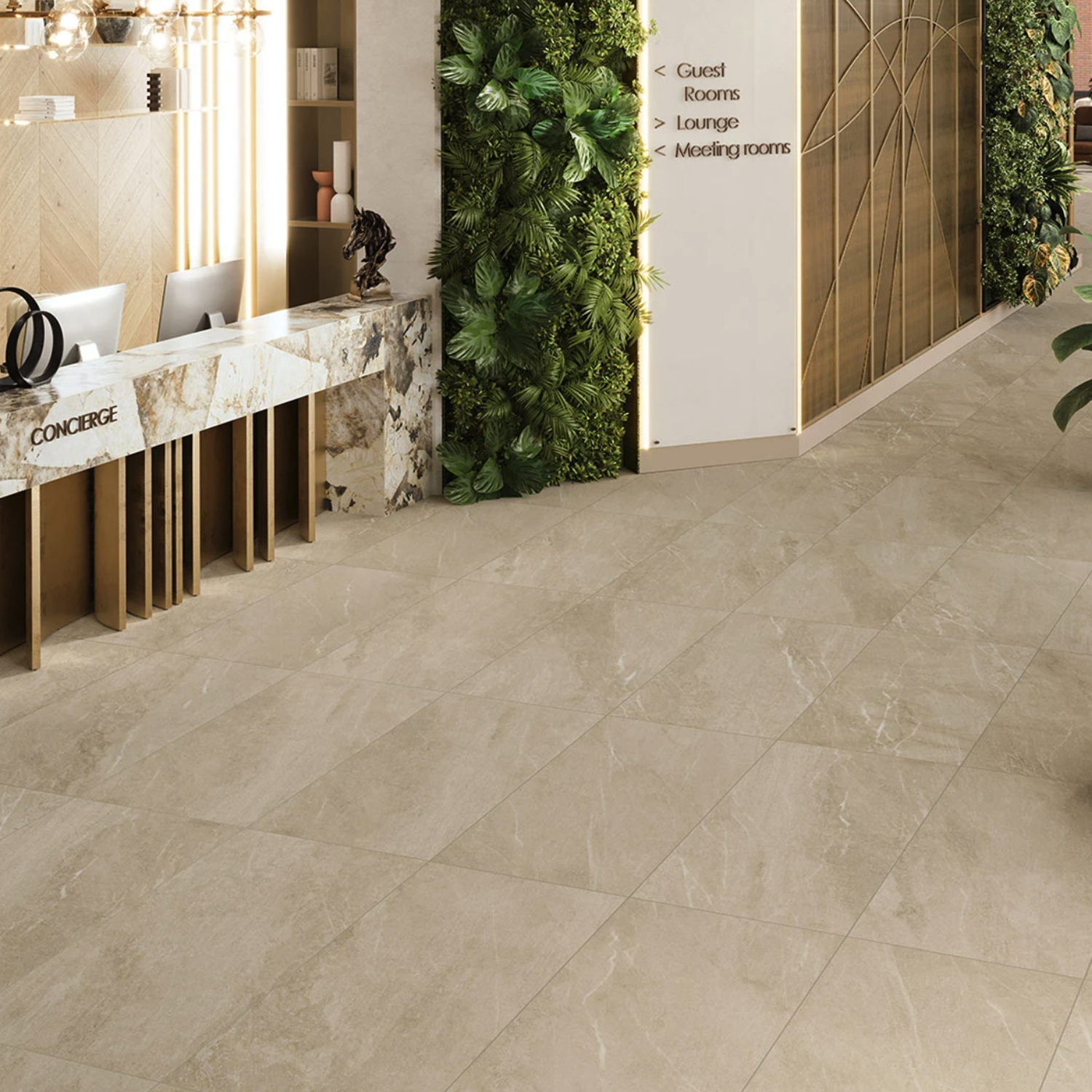 Modern hotel lobby with a Legacy Marblestone - Cream concierge desk, laptops, and decorative items. Lush green plants line the wall, and a sign points to guest rooms, lounge, and meeting rooms. The floor is covered in large beige tiles.