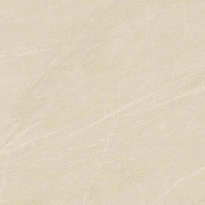 A modern bathroom featuring Legacy Marblestone - Sand tiles, complemented by a gold shower fixture, a recessed shelf with toiletries, and a marble counter adorned with a cup, soap, and brush.