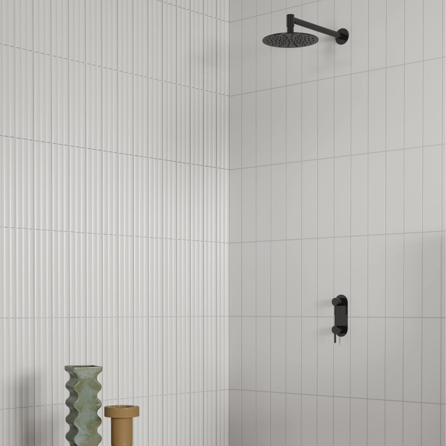 Minimalist shower featuring Marea - Bianco white vertical and horizontal tiles, complemented by a black overhead showerhead and matching black faucet. Two decorative vases, one green and one gold, stand in the corner.