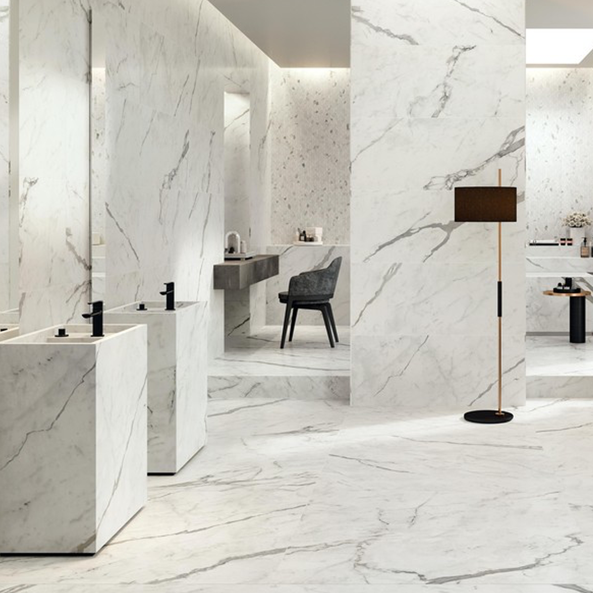 Modern bathroom featuring Marvel Shine - Calacatta Prestigio marble floors and walls, accented by black fixtures, a black chair at the vanity, and a sleek black floor lamp. The space is bright, open, and minimalistic with clean lines and a contemporary design.