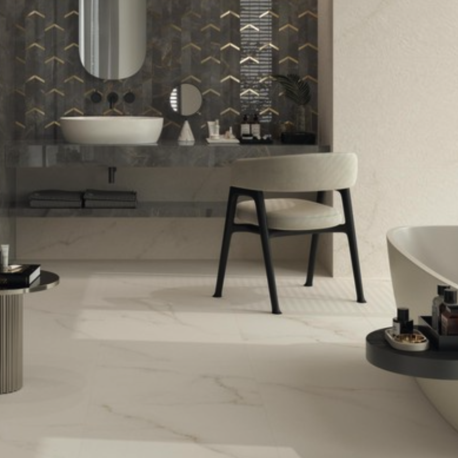 Modern bathroom featuring a floating sink, round mirror, black chair, freestanding bathtub, and decorative shelves. The floor and walls are finished with Marvel X - Calacatta Apuano marble pattern, while the sink wall showcases dark geometric tiles.