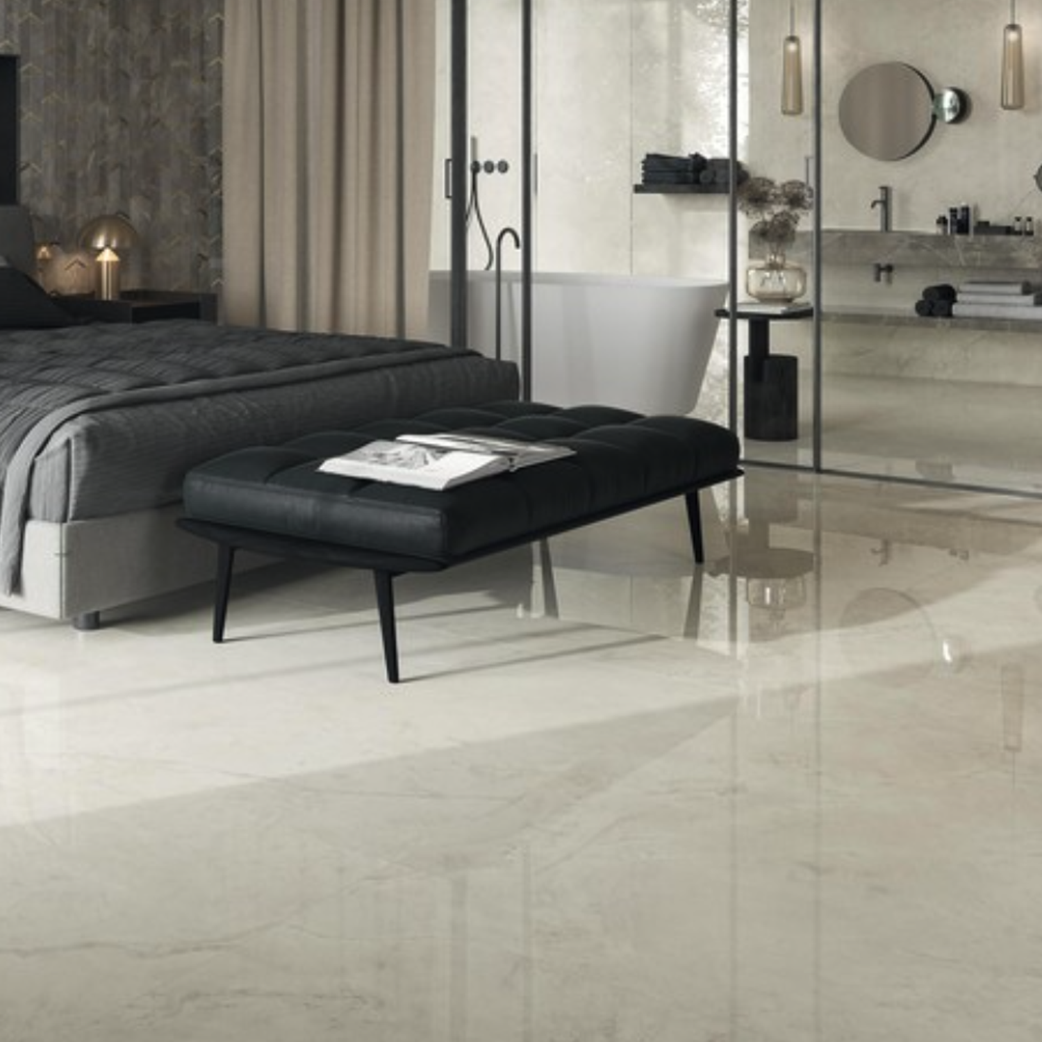 Modern bedroom with a large bed, black bench, and open bathroom featuring a freestanding tub, glass shower, and double sinks. The room showcases contemporary decor and glossy Marvel X - Calacatta Perla marble floors.