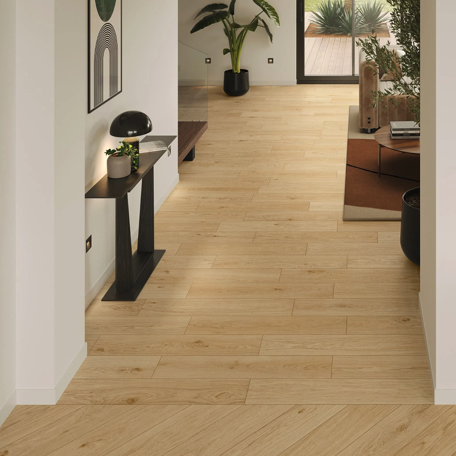 Modern hallway featuring Memory Oak - Vanilla light wood flooring, white walls, a black console table, lamp, wall art, large green plant, and a view into a cozy living area with garden outside.