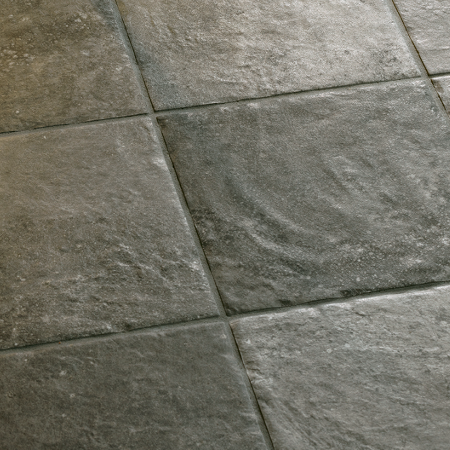 Close-up of Molo Audace - Bocca Di Lupo gray stone tiles featuring a textured, slightly uneven surface and visible grout lines separating each square tile.