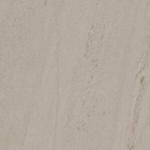Two rattan chairs with gray cushions sit beside two round speckled tables. A small plant and an open magazine rest on the larger table. The floor features Moonstone - Beige tile arranged in a staggered pattern.