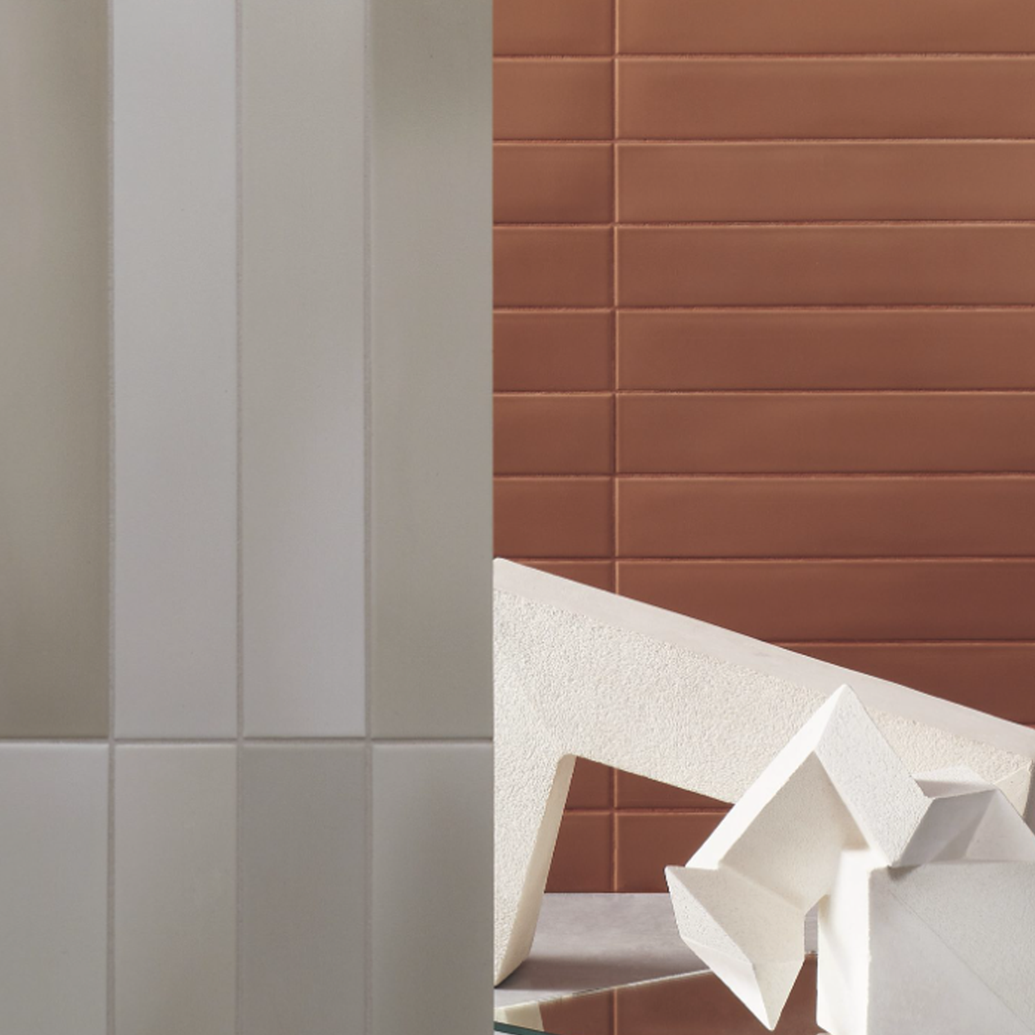 Pigmento - Beige rectangular tiles on the left, rust-colored horizontal tiles on the right, and abstract white geometric sculptures in the foreground.