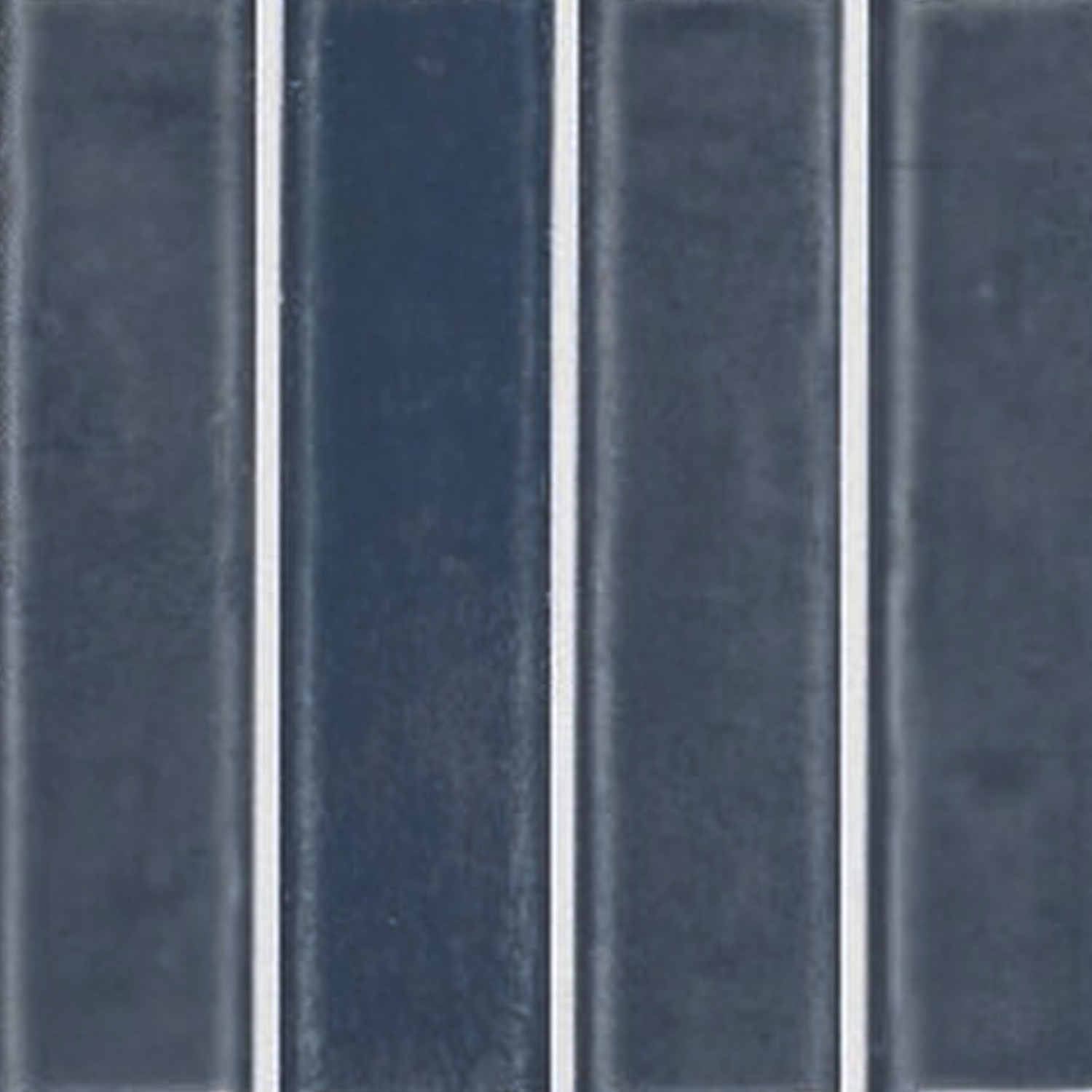 Pim Pam Pum - Pum Blue rectangular tiles in a dark blue shade, featuring thin white grout lines and arranged vertically in a grid pattern. The smooth, glossy surface enhances their striking appearance.
