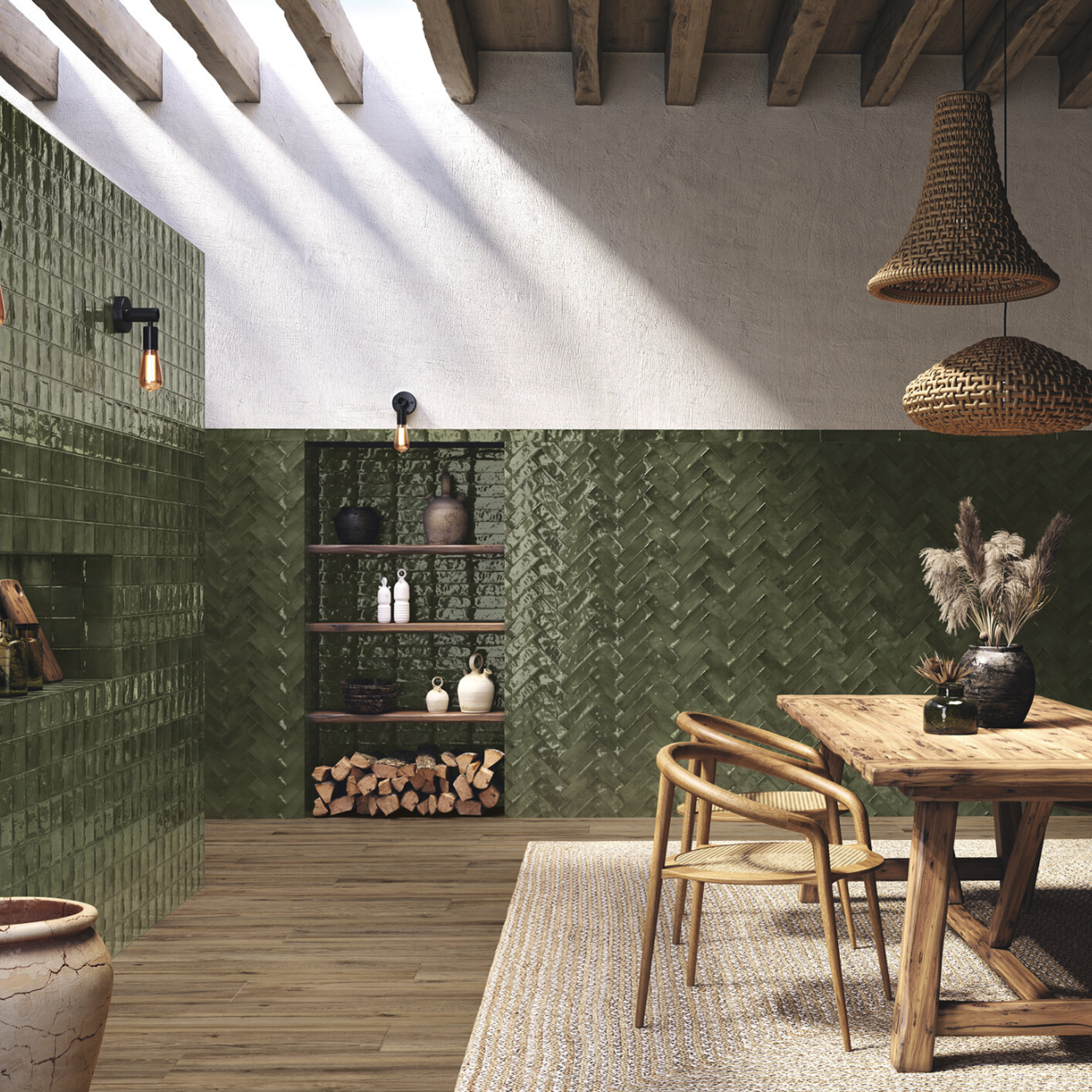 A rustic dining area featuring Seville - Green tile walls, wooden beams, a wooden table with chairs, woven pendant lights, a shelf displaying vases, and stacked firewood, with sunlight streaming in from a window above.
