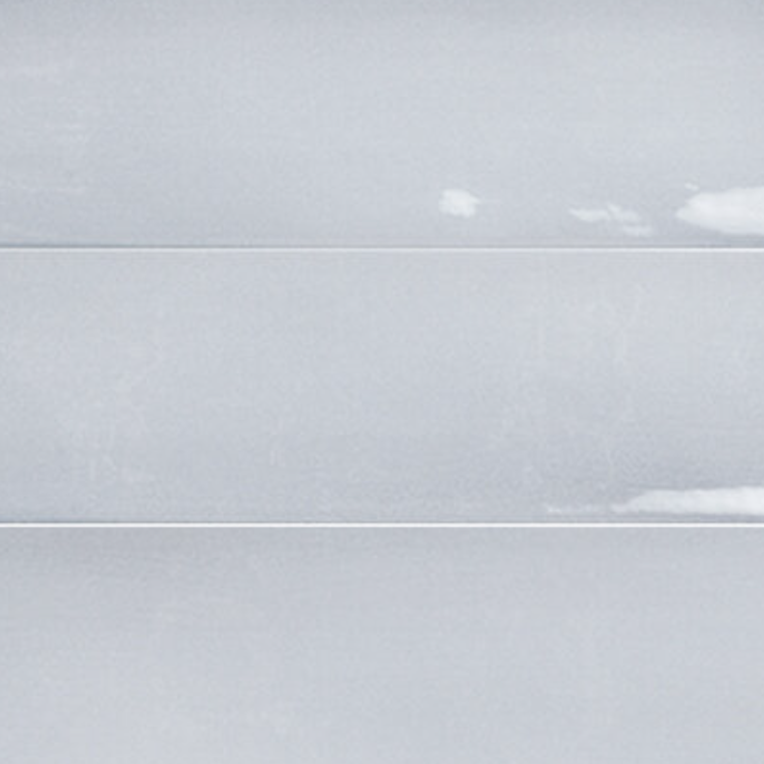 Three horizontal, slightly weathered, pale gray Sfumature - Azzurro wooden planks with subtle white patches, giving a lightly textured appearance.