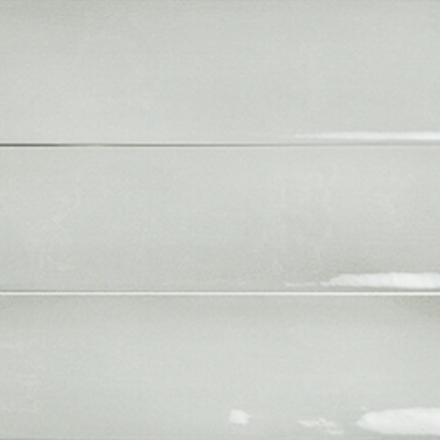 Sfumature - Verde tiles are glossy white, rectangular in shape, and arranged horizontally with visible grout lines. Their surface features slight reflections and a smooth, clean appearance.
