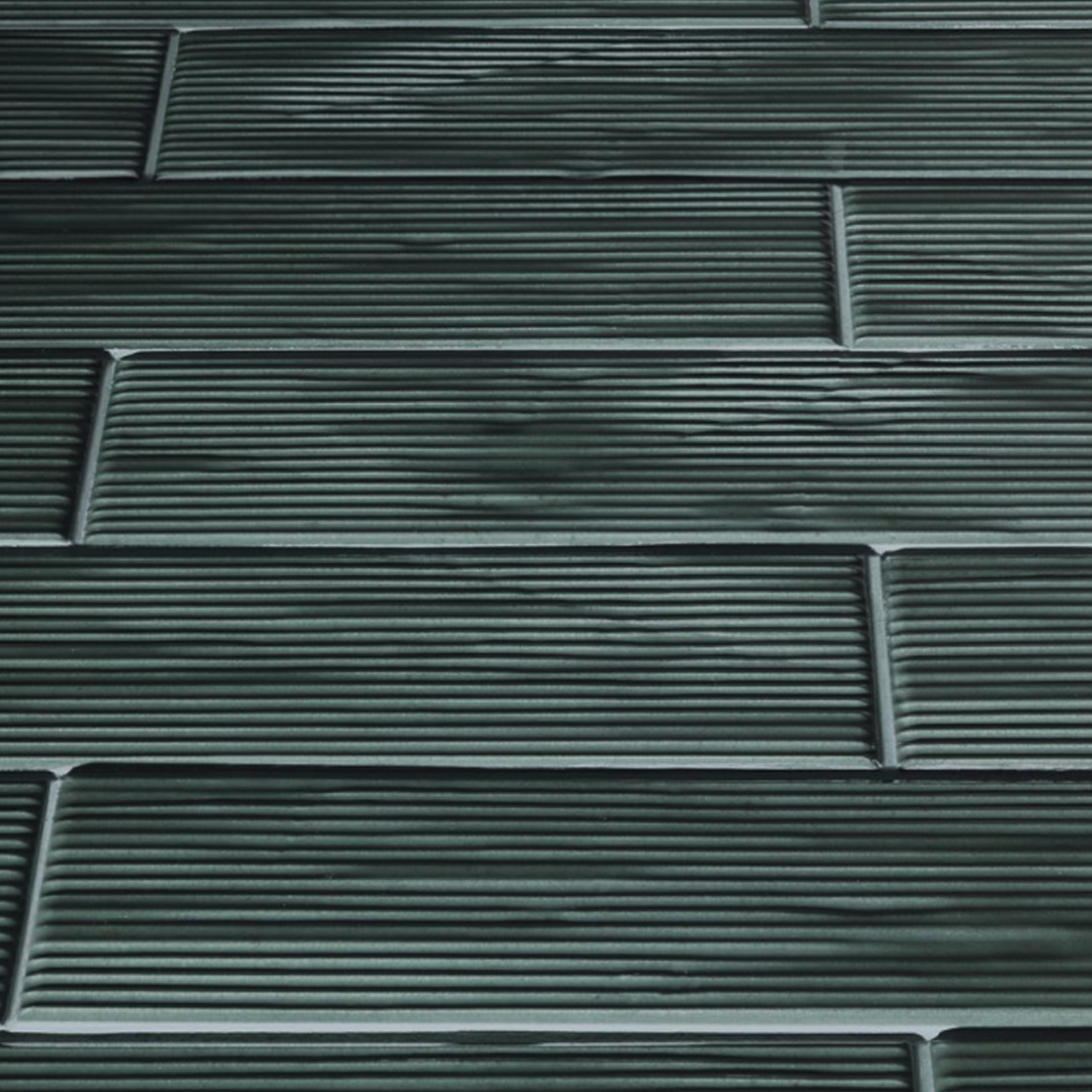 Close-up of Swing - Musk dark green rectangular tiles arranged in a staggered brick pattern, each featuring horizontal grooves for a textured, linear look.