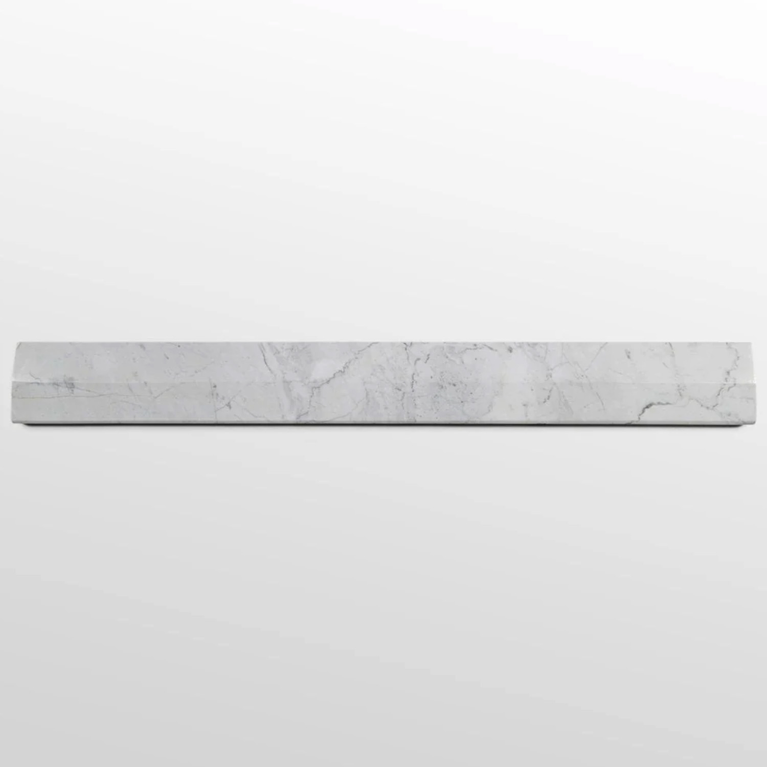 A long, narrow strip of Venatino Carrara marble threshold with subtle gray veining is placed horizontally against a plain, light gray background.