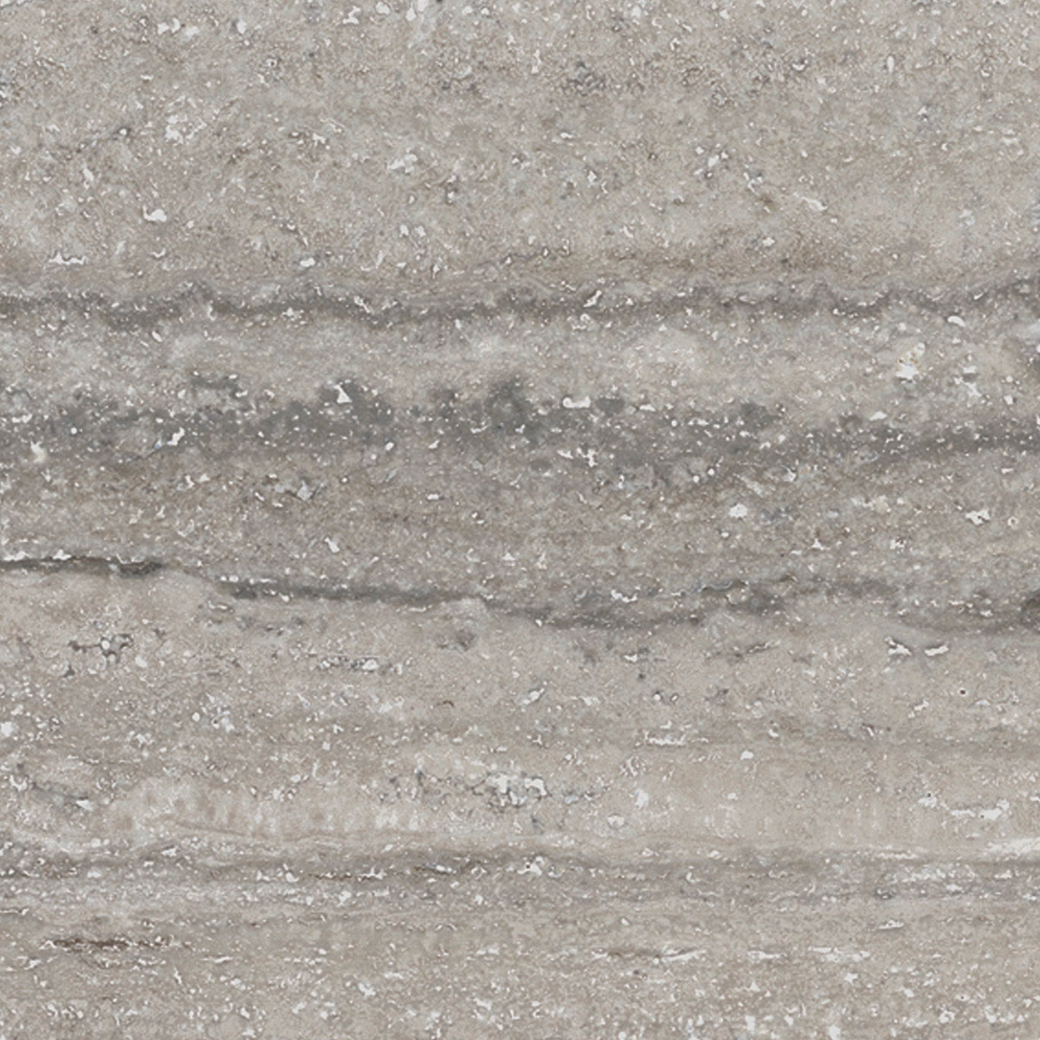 Close-up of Travertino Al Contro - Grigio Al Contro, showcasing a gray stone surface with horizontal, uneven layers and a rough, textured appearance, accented by small white and dark specks throughout.