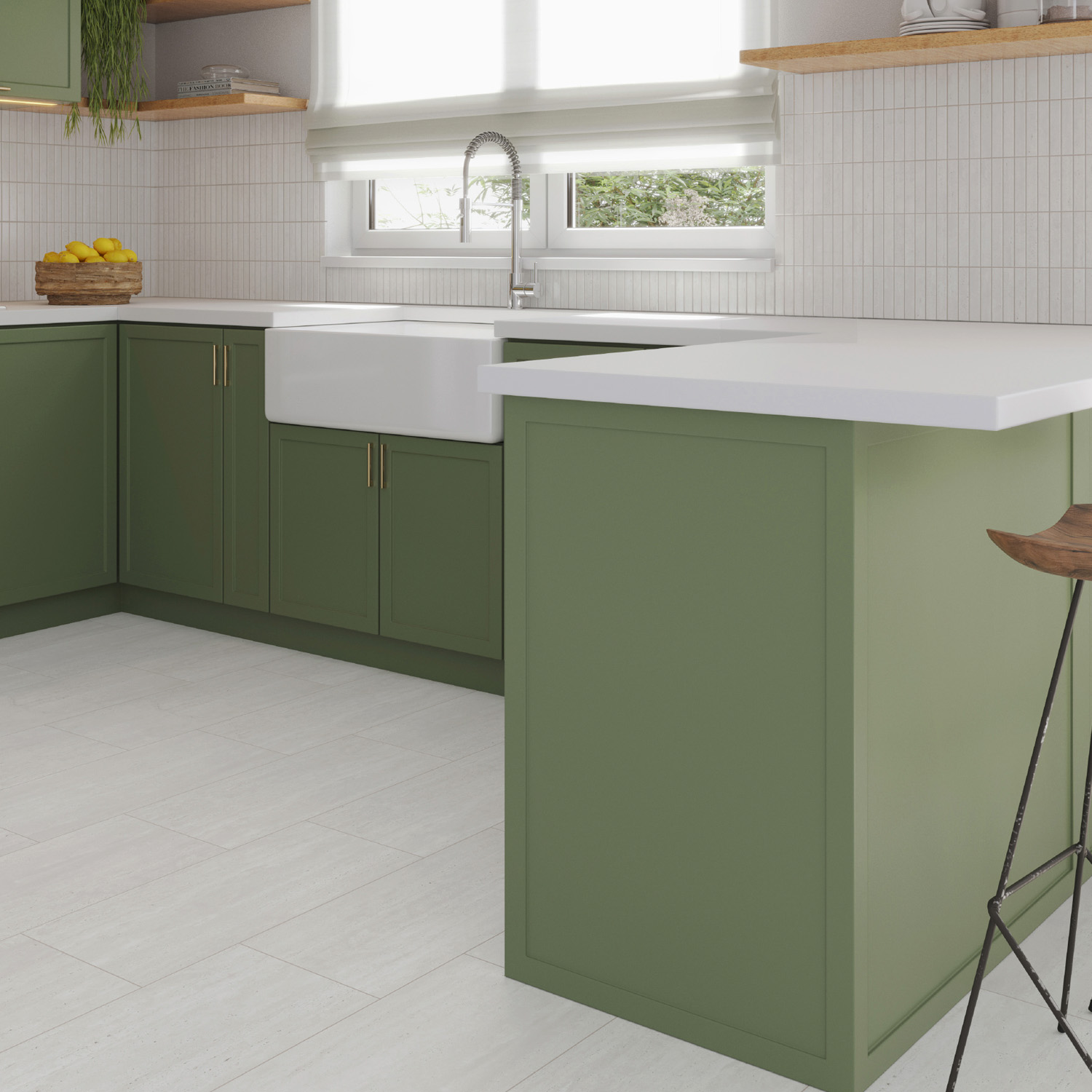 A modern kitchen featuring sage green cabinets, Travstone - White countertops, a farmhouse sink, and a window with white blinds. On the counter sits a wooden bowl of lemons, and there’s a barstool with a wooden seat.