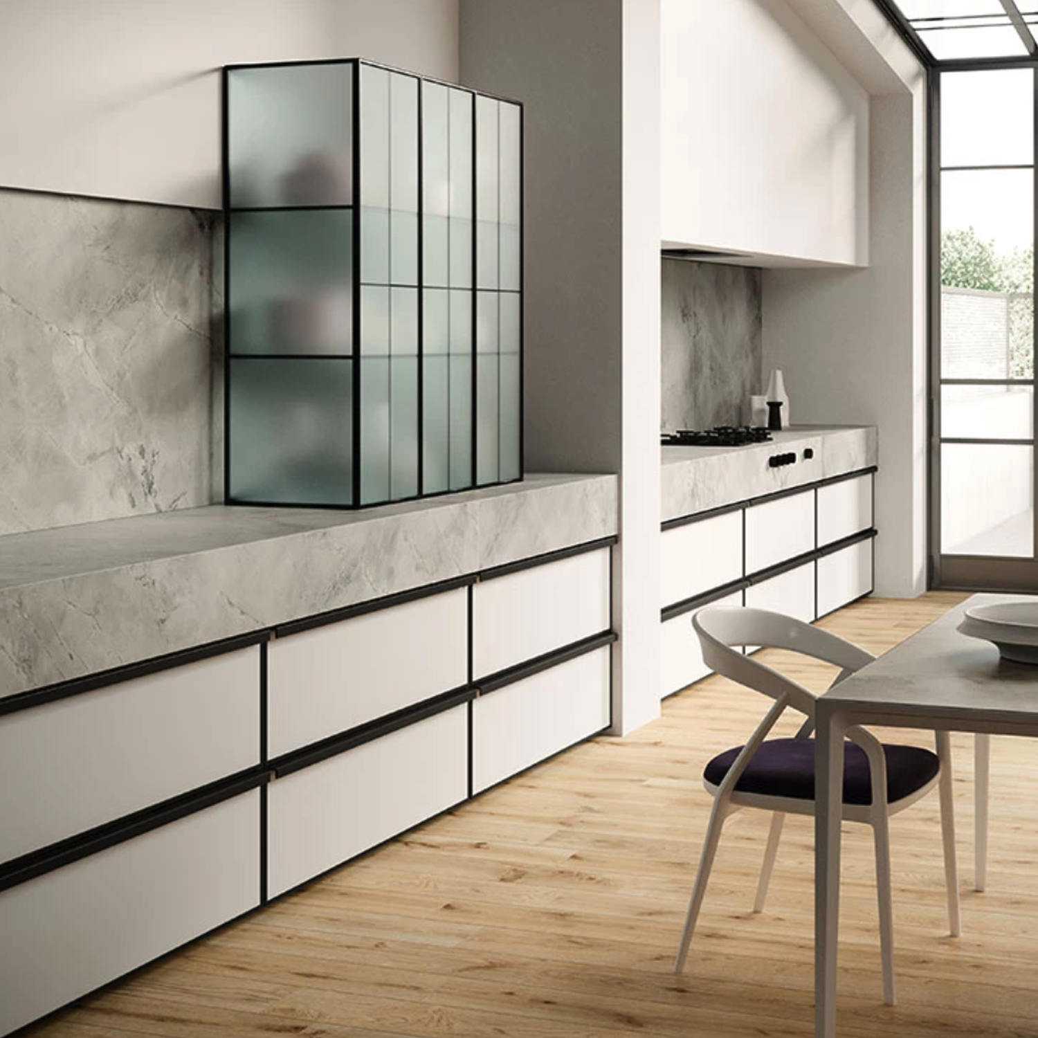 A minimalist kitchen features White Cloud cabinetry paired with light wood floors, matte gray countertops, a frosted glass cabinet, and large windows that fill the space with natural light. In the foreground sits a dining table surrounded by chairs.