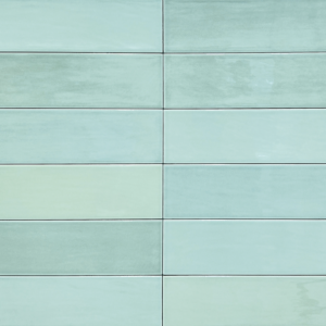 A modern patio featuring wicker chairs and a small table beside a clear swimming pool, accented with potted flowers and a slatted wooden privacy screen, is elevated by the refreshing tones of Zellige - Mint tiles.