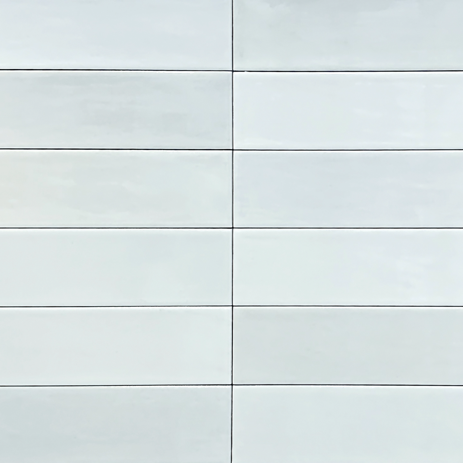 Zellige - White tiles are arranged in a horizontal grid pattern with thin dark grout lines separating each one. These rectangular tiles feature a smooth, glossy finish and are evenly spaced for a clean, modern look.