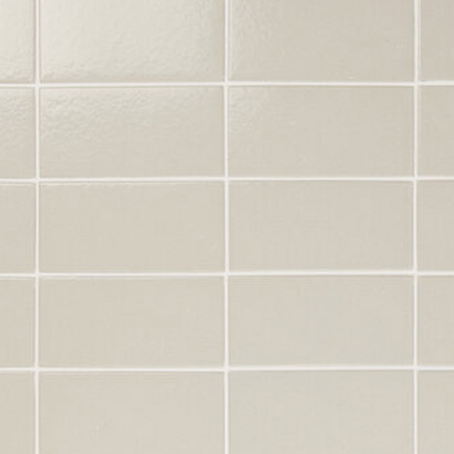 Close-up of a beige tiled wall featuring Arka - Arka Bone tiles with a glossy surface. The rectangular tiles are arranged in a grid pattern and separated by white grout lines.