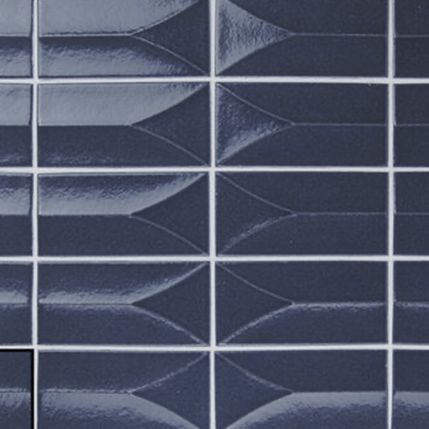 Arka - Forma Blue tiles showcase a glossy dark blue surface with a geometric, arrow-inspired pattern arranged in a grid. Accentuated by white grout lines and a reflective finish, one tile in the lower left stands out as a solid color square.