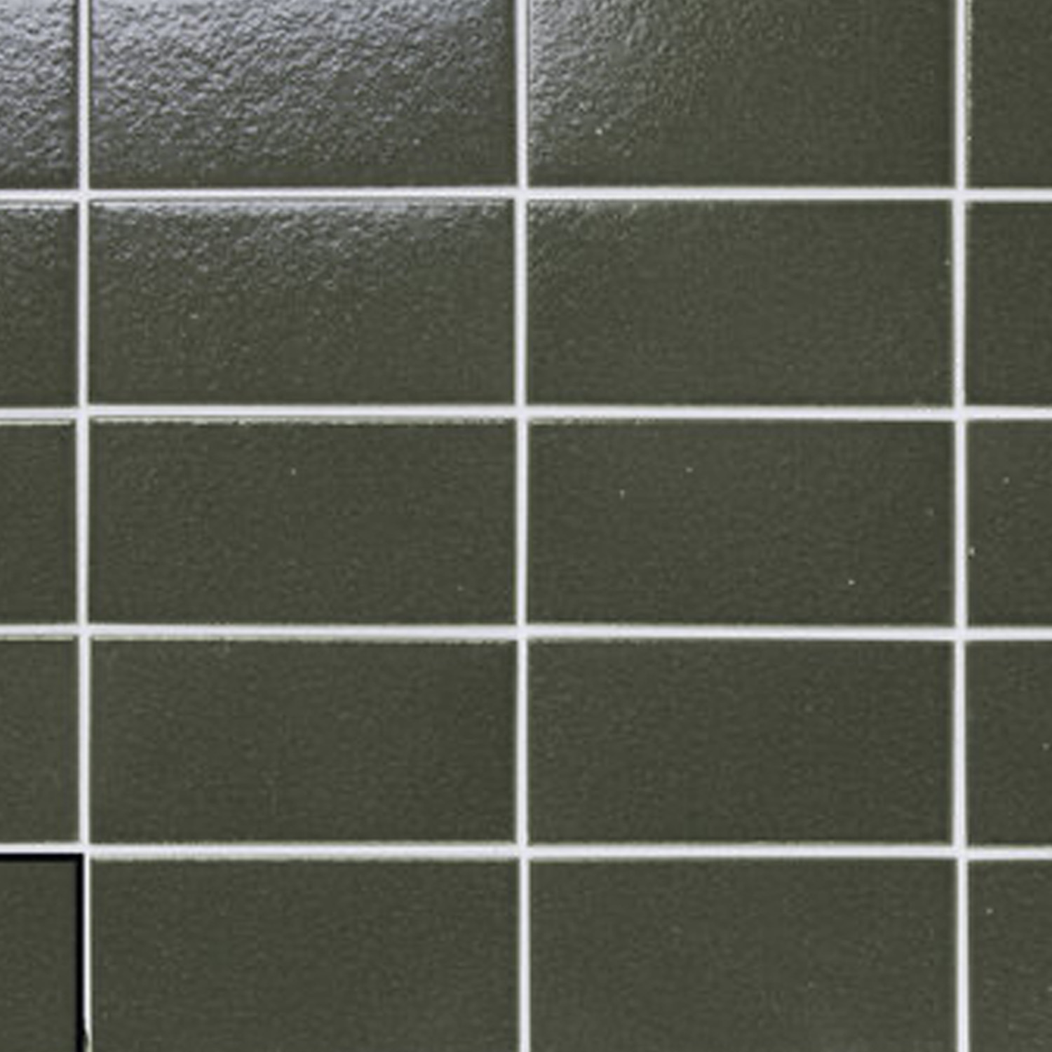 A grid of shiny dark green Arka tiles with white grout, with one tile missing in the bottom left corner to reveal a black space behind it.