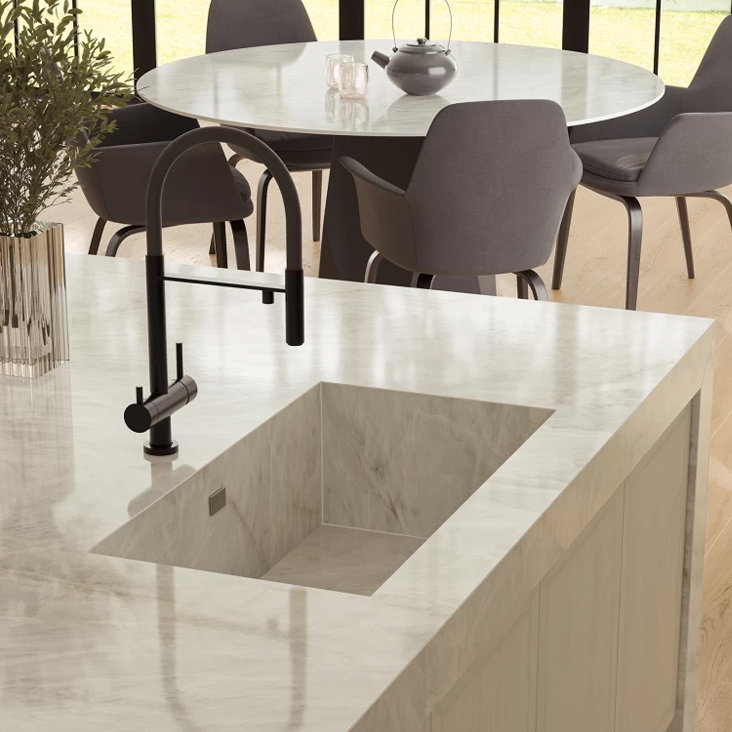 A modern kitchen features a Crystal White marble countertop with an integrated sink and black faucet. In the background, there’s a round dining table with gray chairs and a teapot by large windows overlooking greenery.