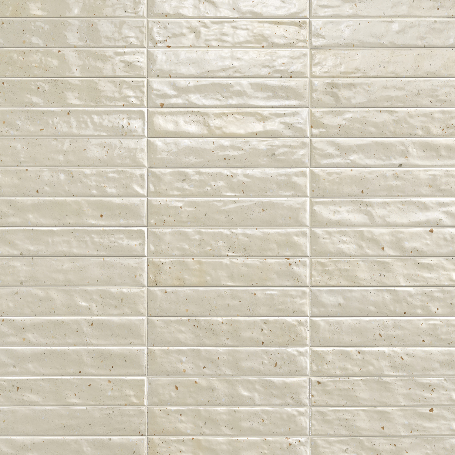 Via Del Sale - Beige features glossy, off-white rectangular tiles with a gentle texture and understated brown speckles, laid in a horizontal brick pattern.