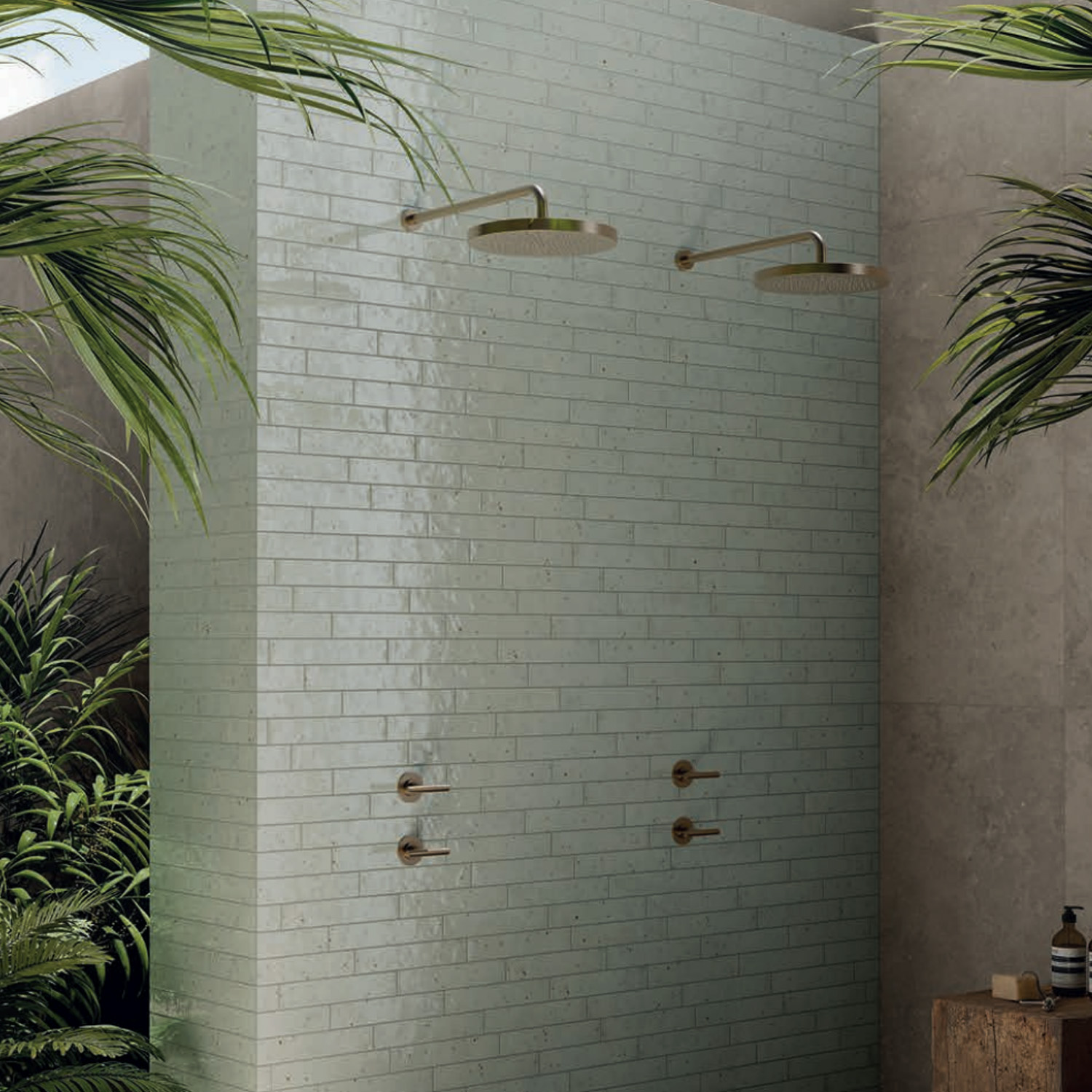 Outdoor shower area with two rainfall showerheads, Via Del Sale - Sage tile, and leafy tropical plants surrounding the space.
