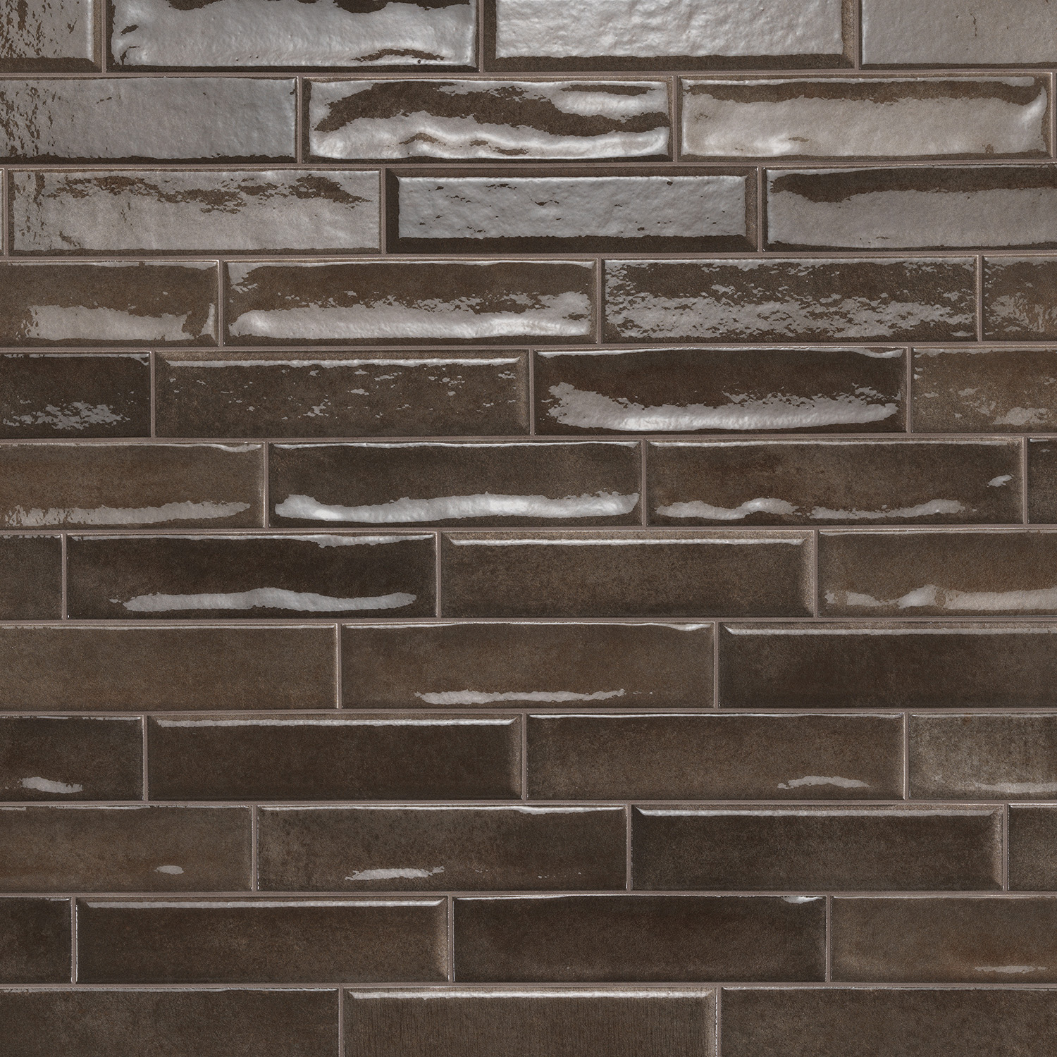 Vibe - Mud subway tiles in a glossy, dark brown finish are arranged in a staggered brick pattern; some tiles reflect light, while others appear more matte, resulting in varied texture across the surface.